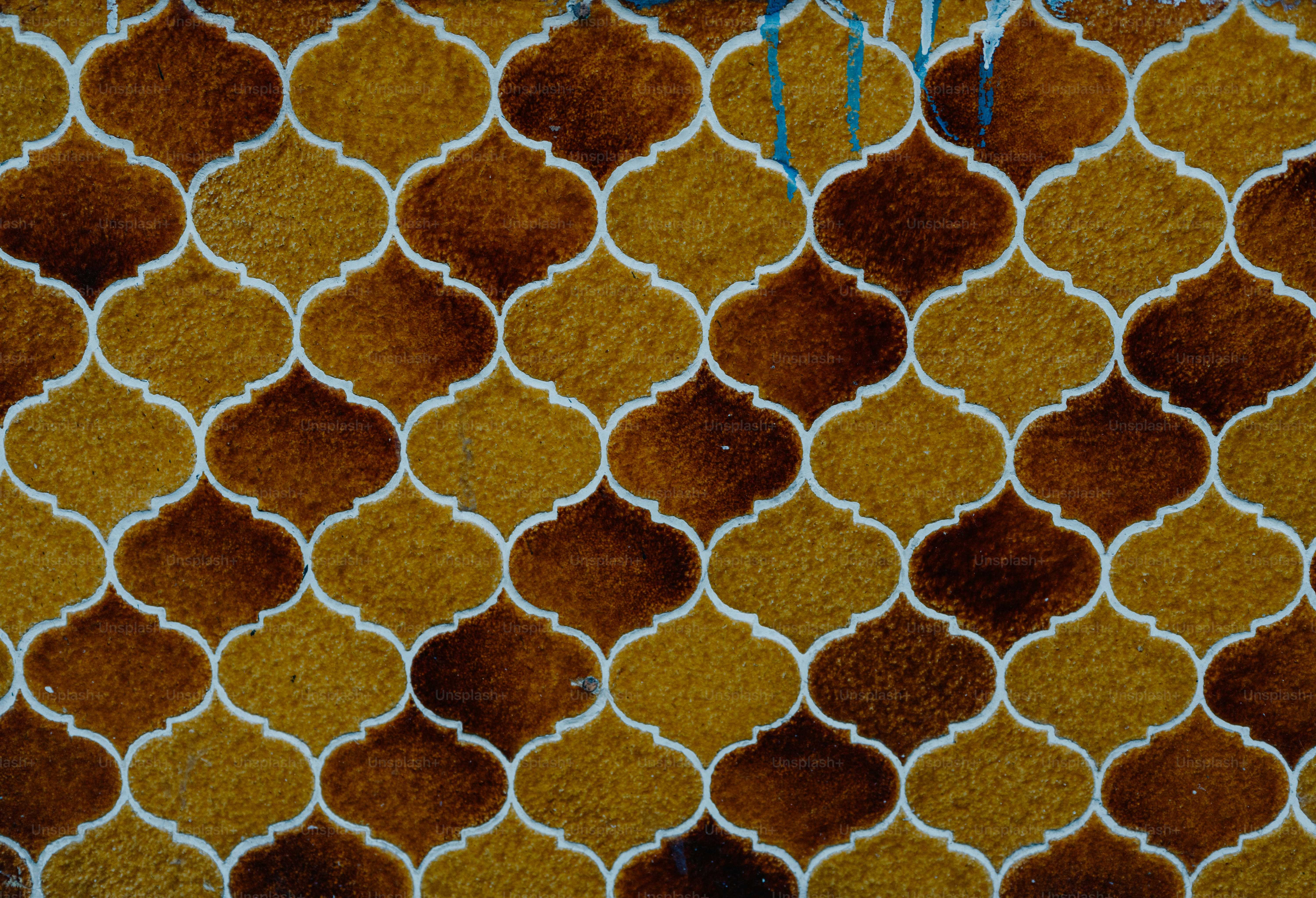 A repeating pattern of brown and yellow quatrefoil tiles