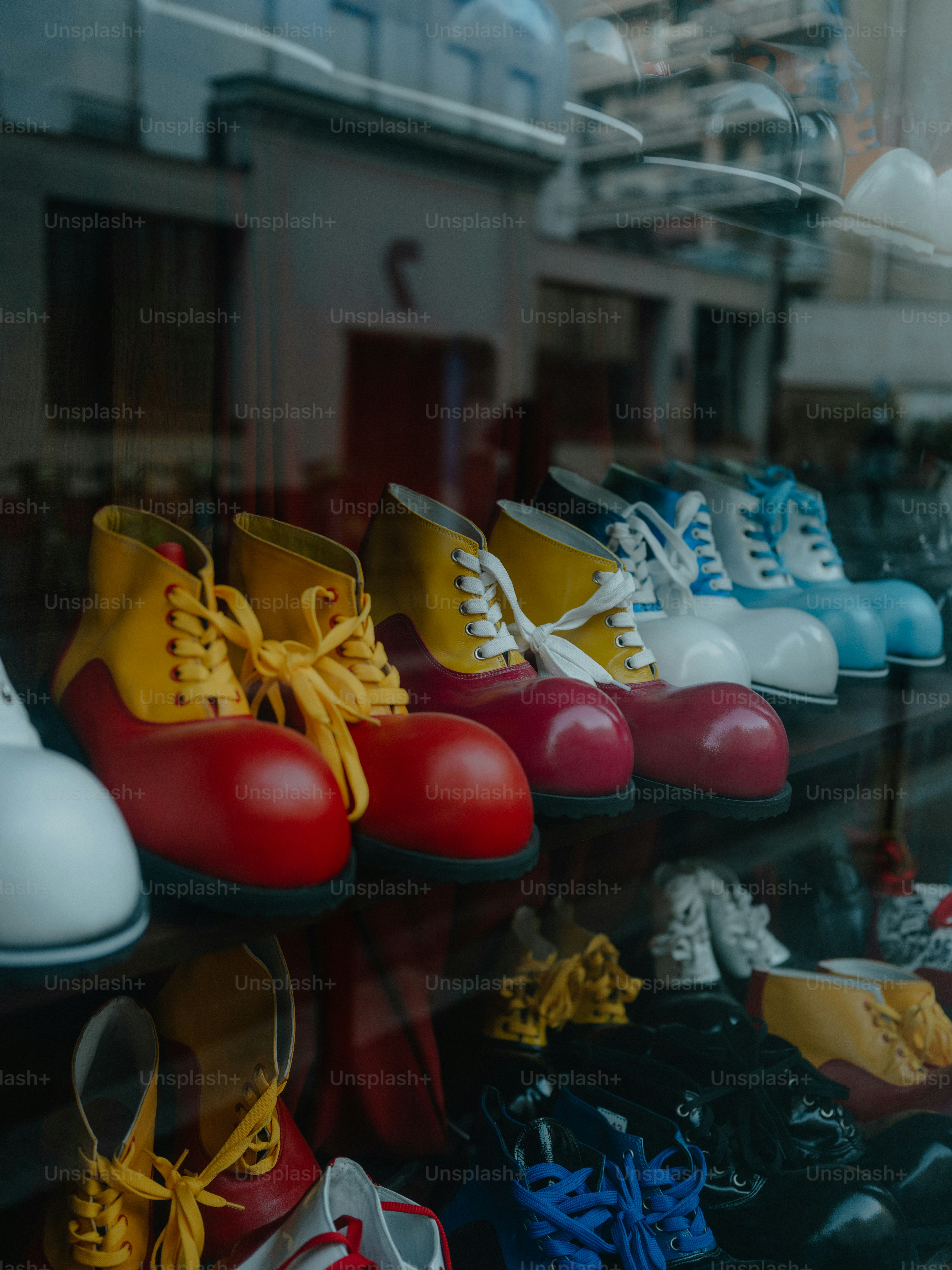 Zapatos de payaso de colores exhibidos en el escaparate de una tienda.