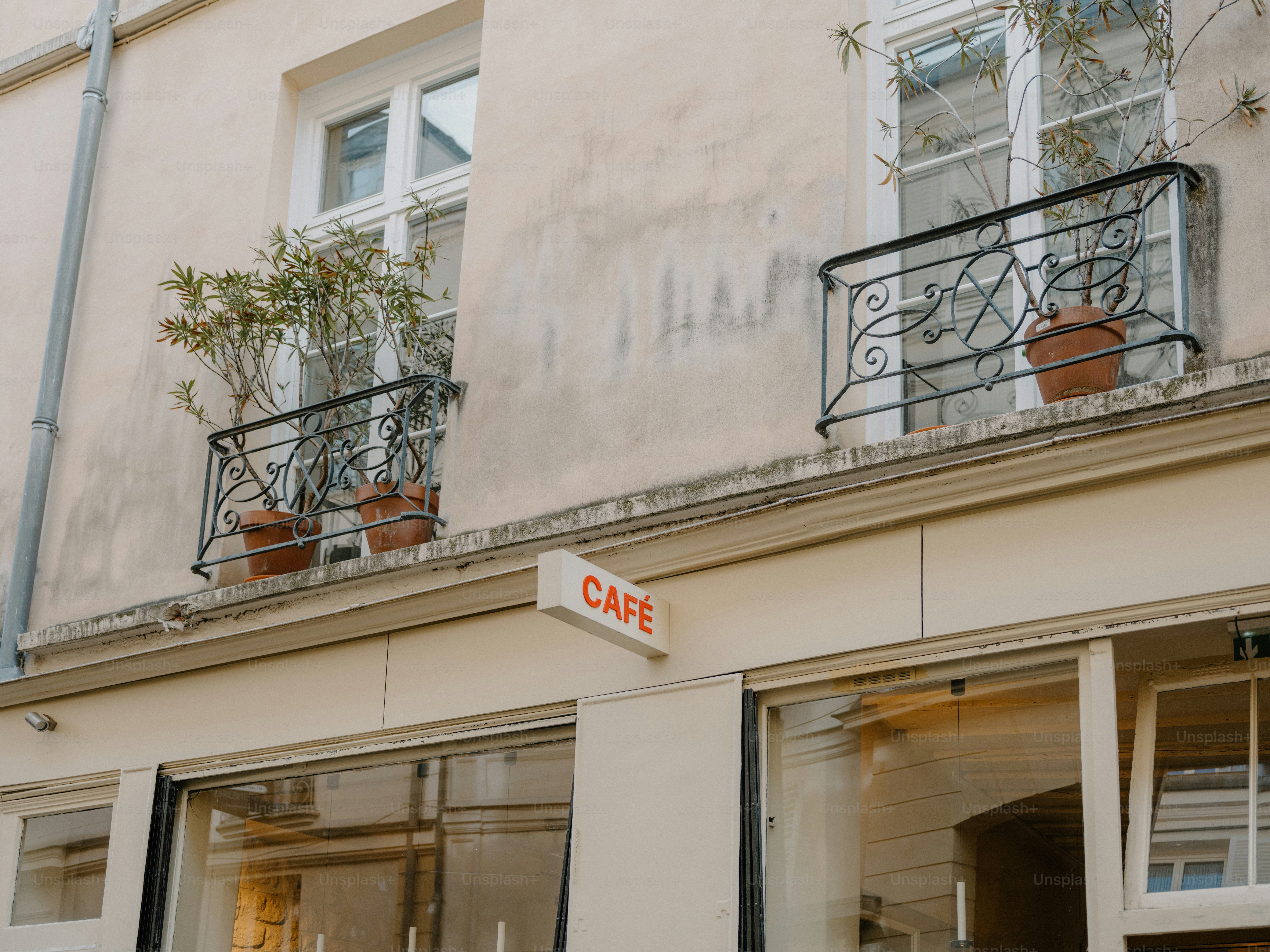 A cafe sign hangs above storefront windows.
