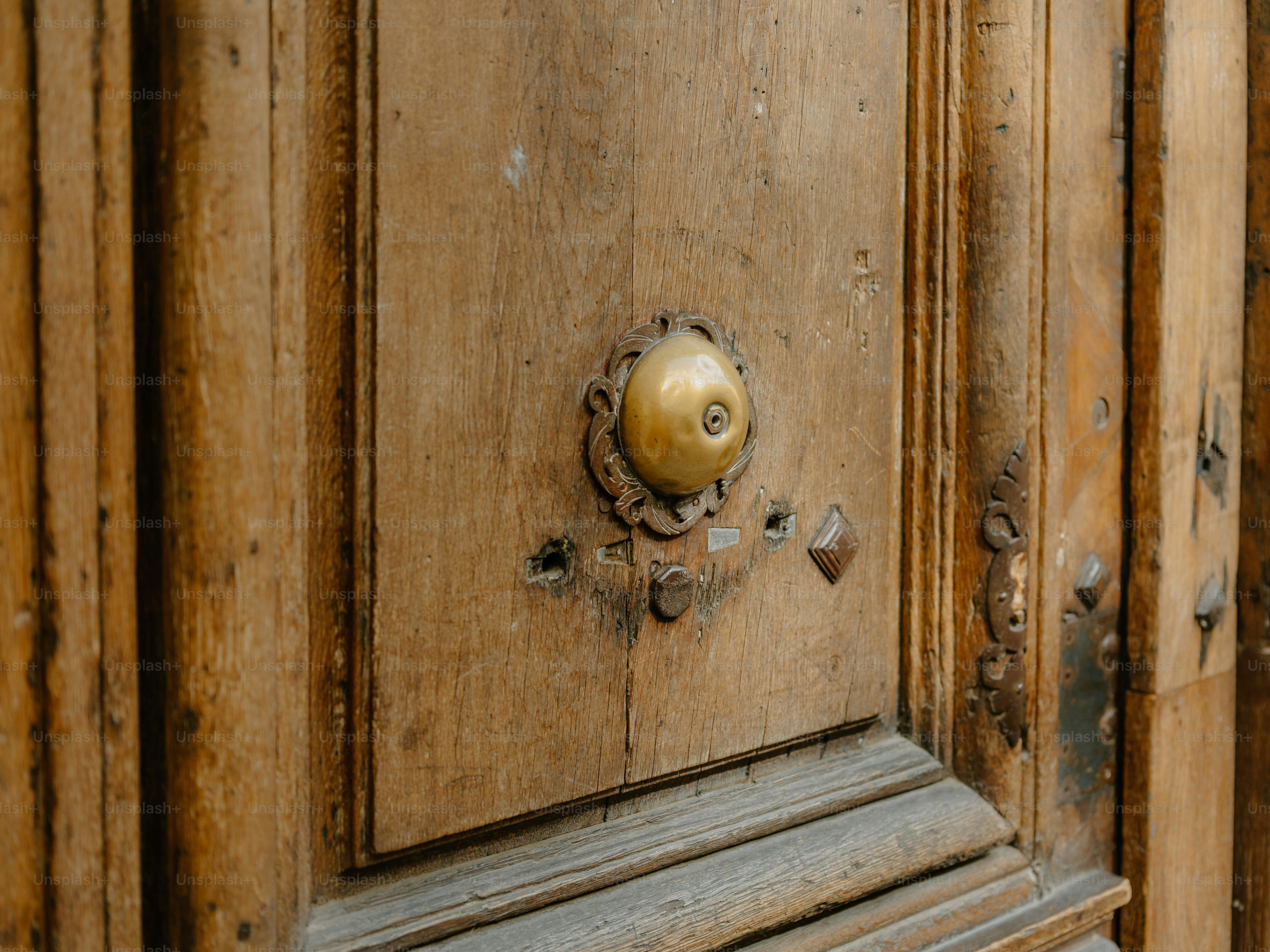 Close-up of an old wooden door with a brass knob.