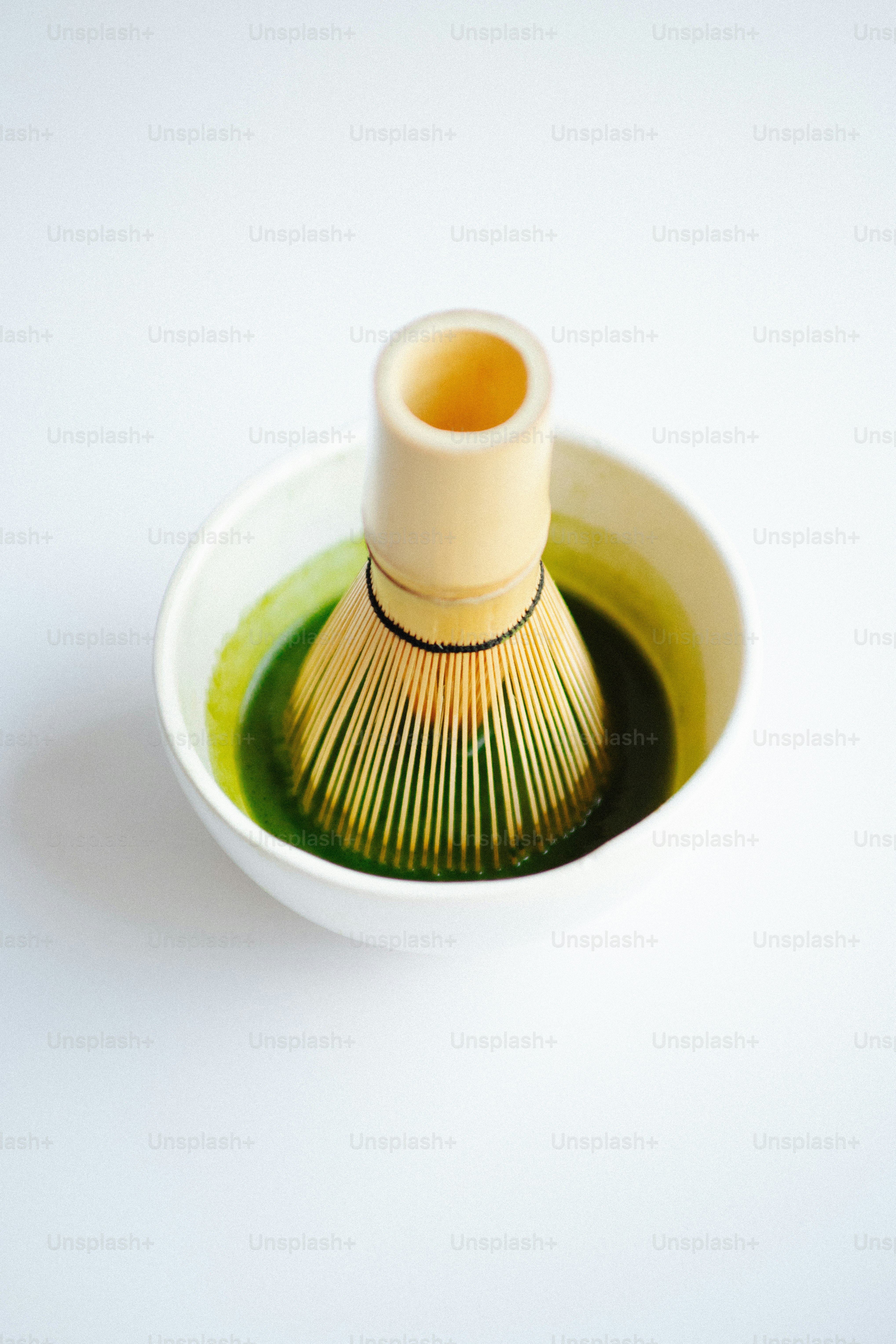 Fouet en bambou dans un bol de thé matcha