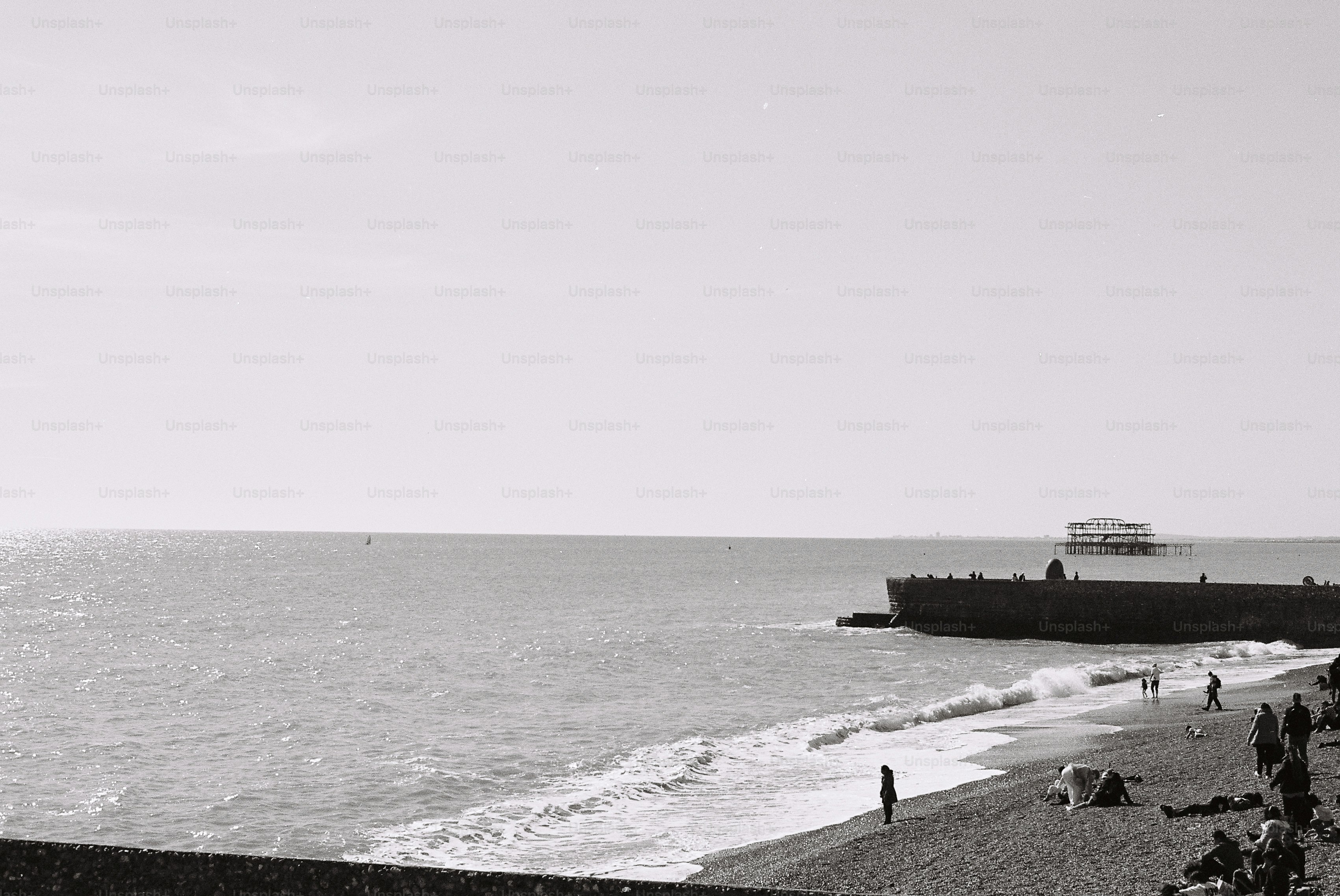 People relax on a pebble beach by the ocean