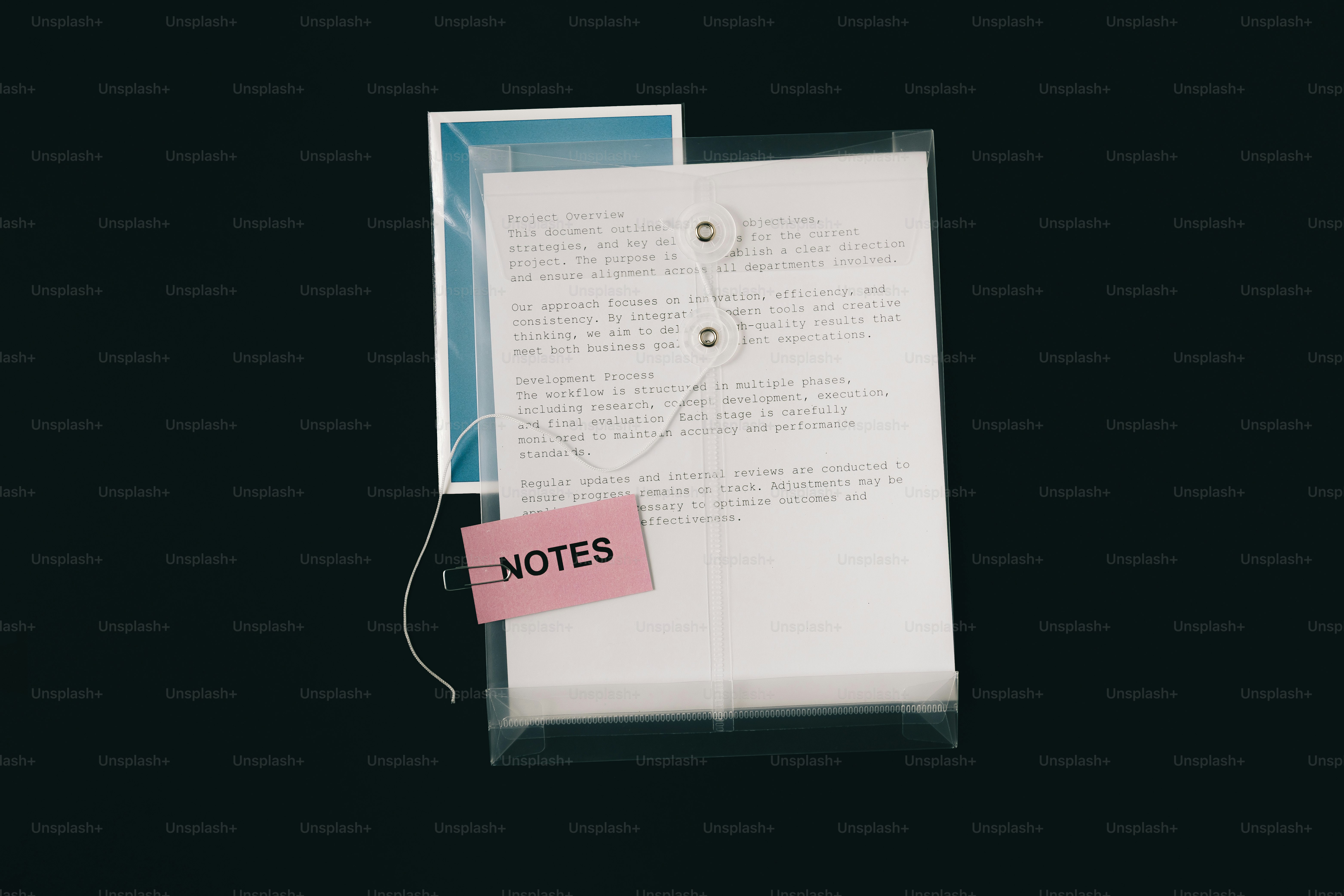 Les papiers dans un dossier transparent avec une étiquette rose « notes » (notes) en rose.
