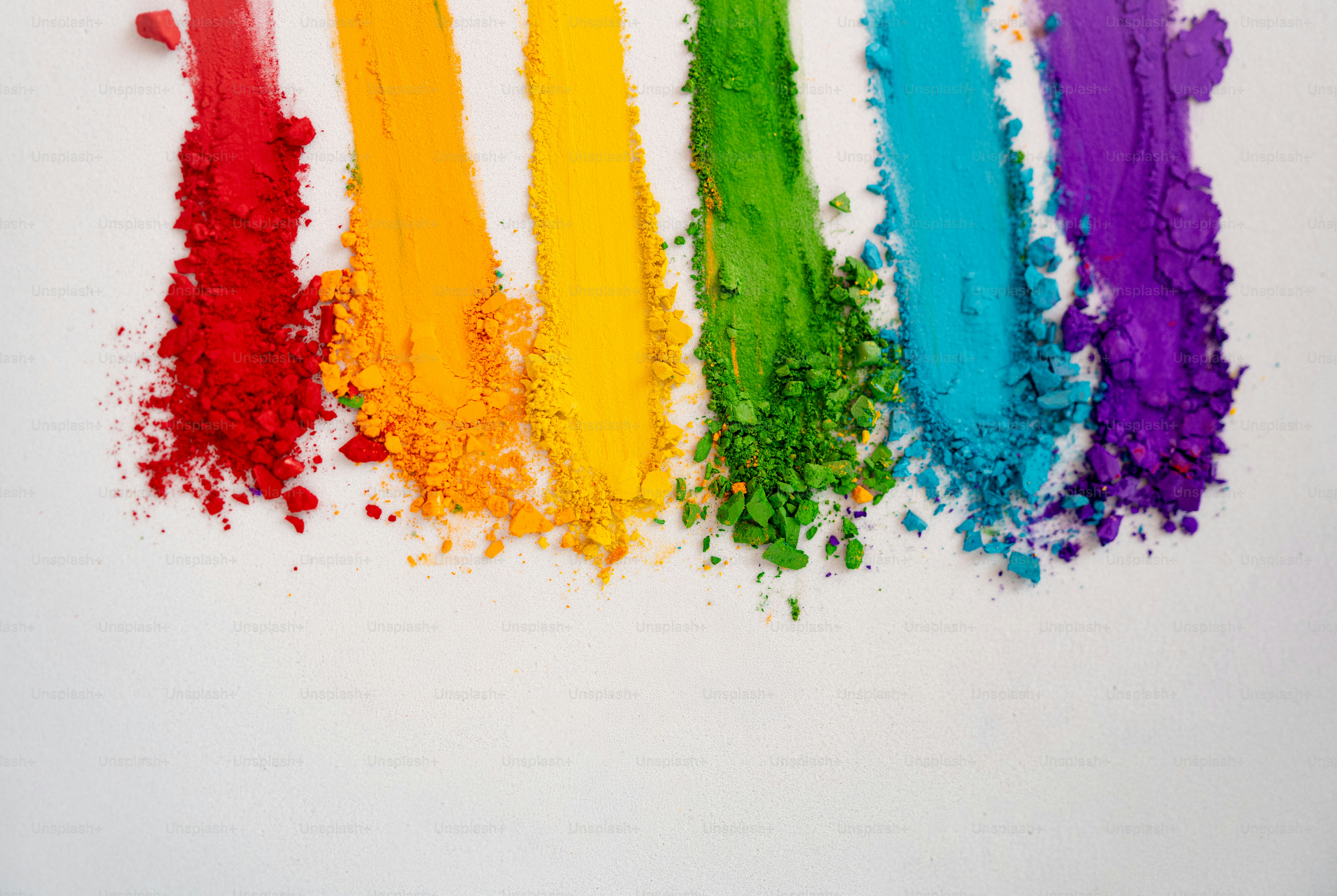 Rainbow colored powder streaks on white background