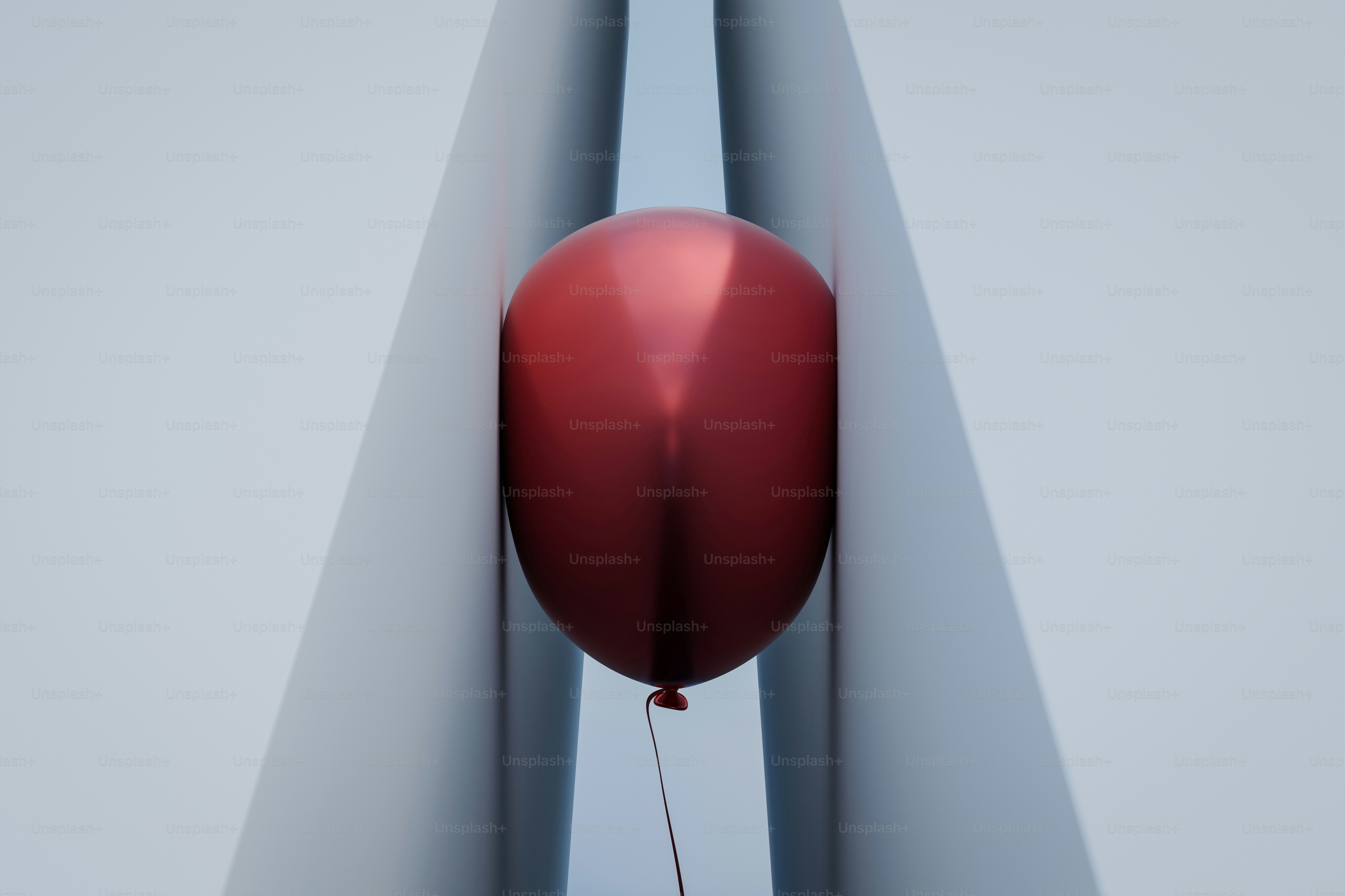Un globo rojo atrapado entre dos estructuras blancas.