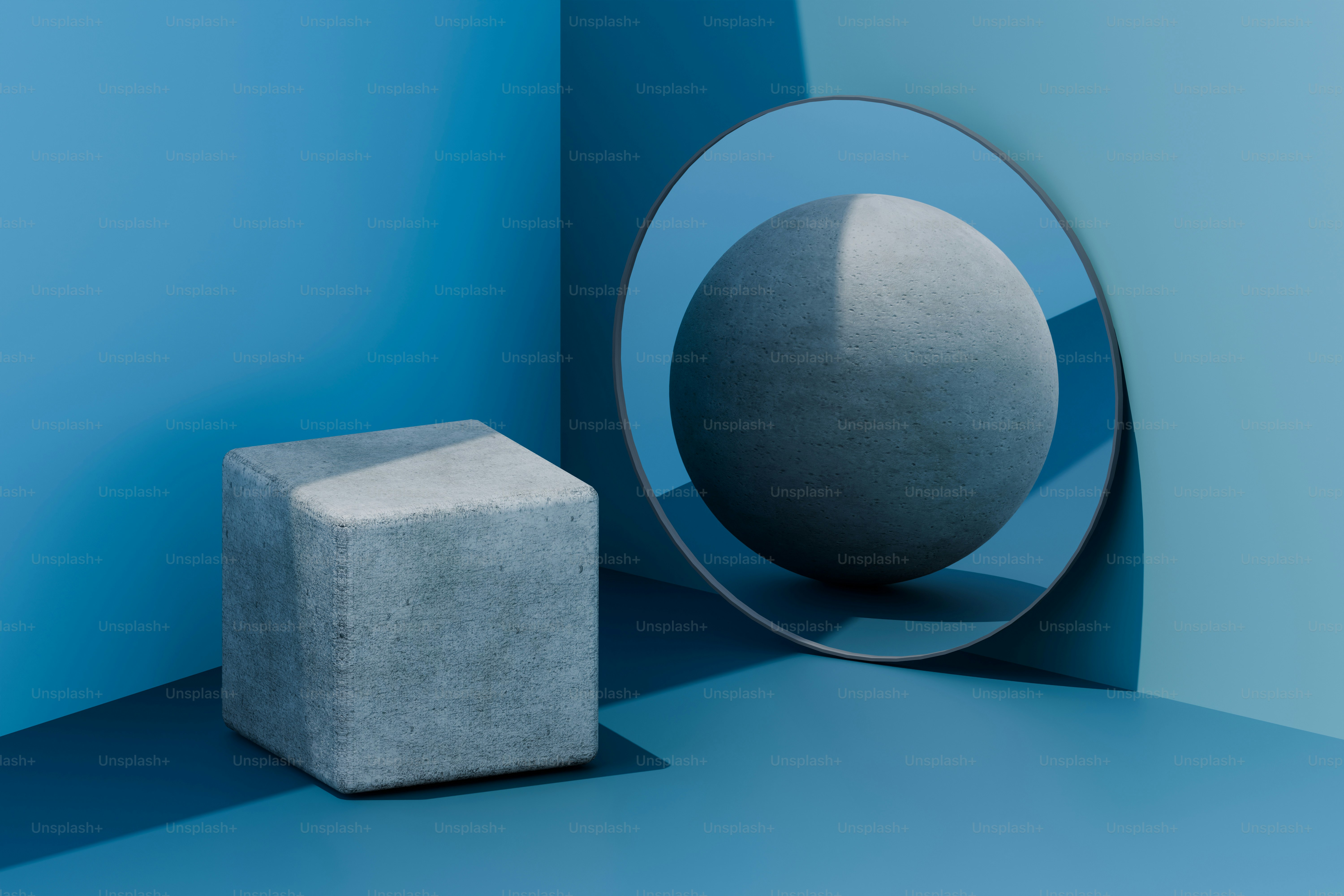 Un cubo gris refleja una esfera en una habitación azul.