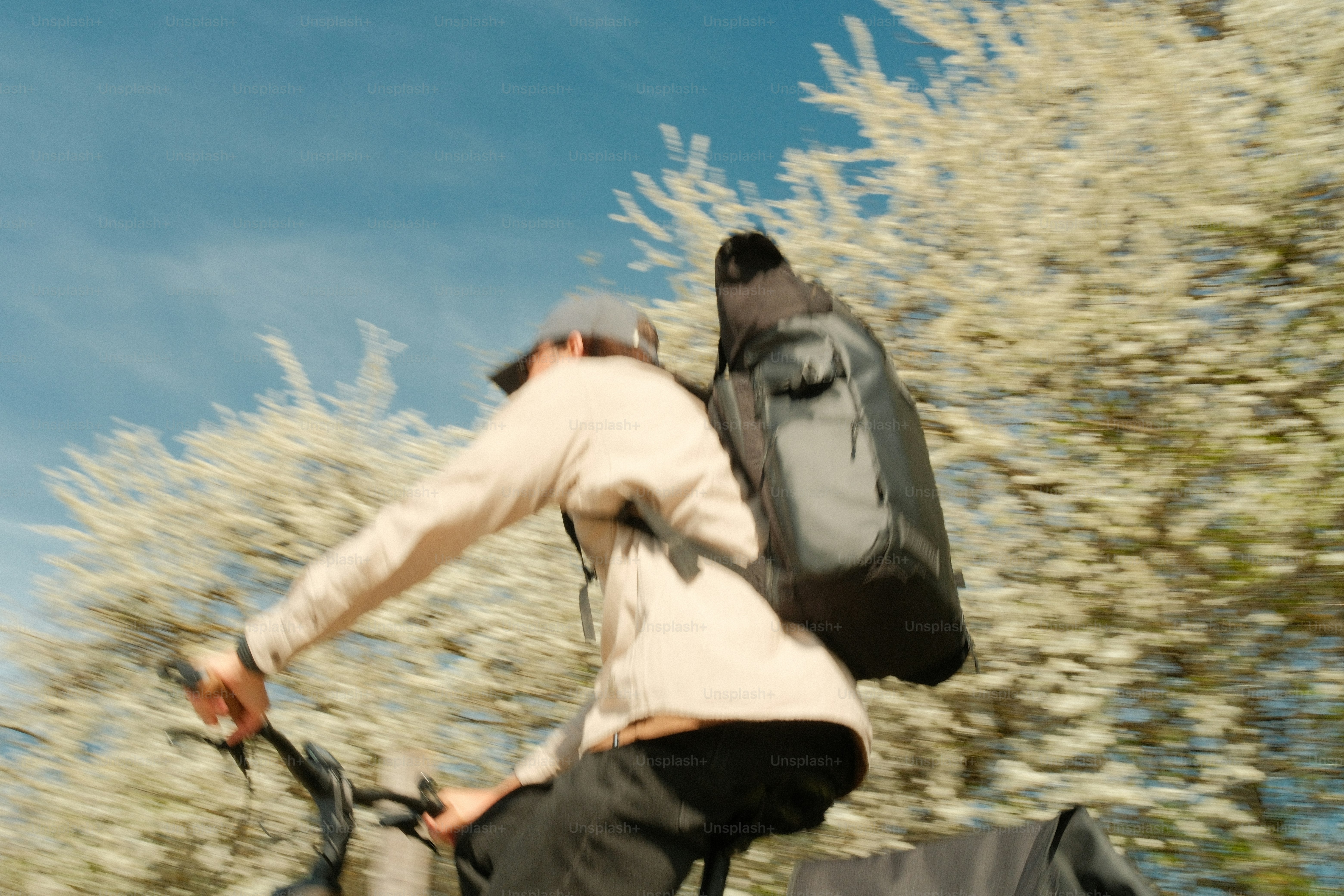 Person riding a bicycle with a backpack outdoors