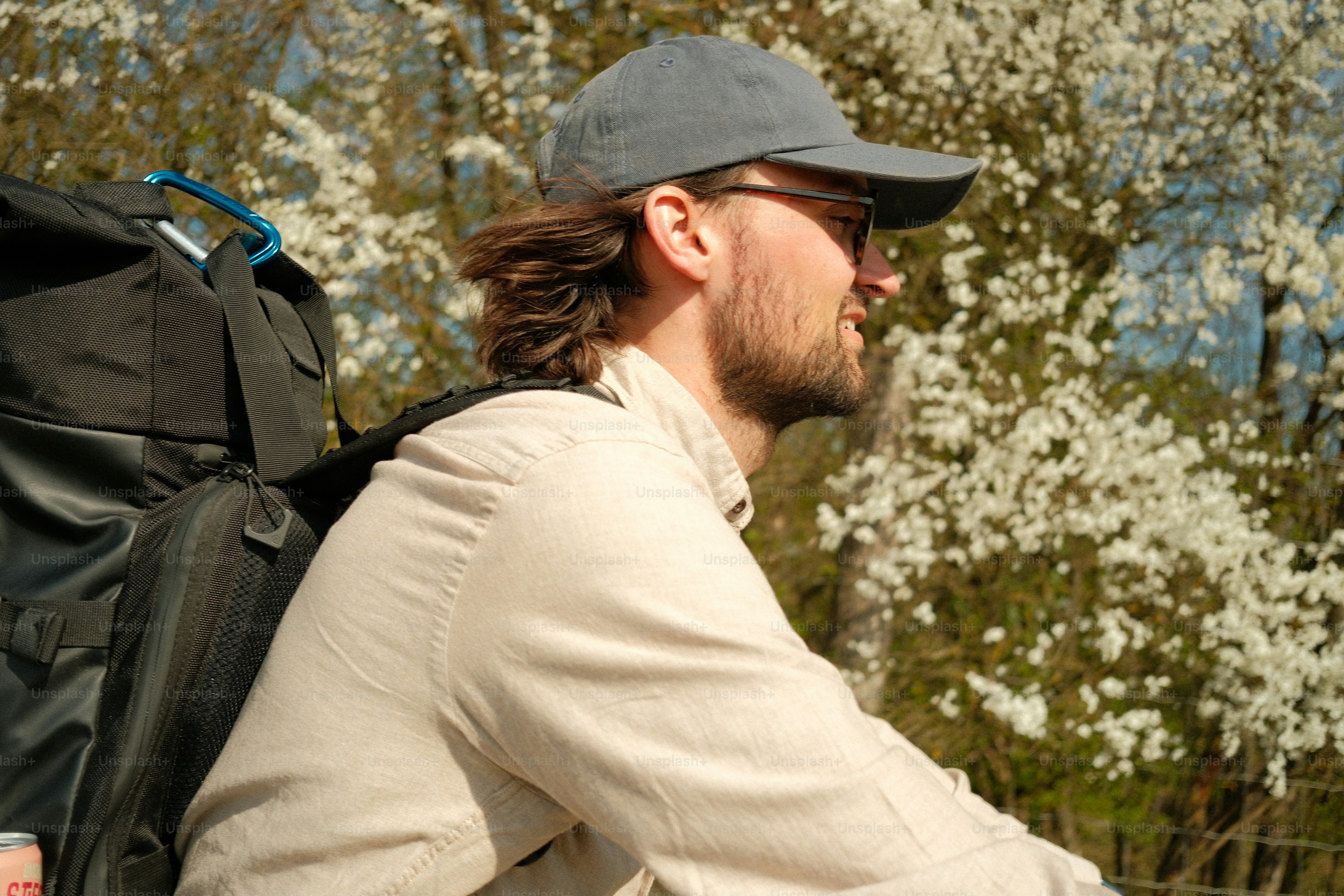 Pria mengenakan topi bisbol dan kacamata dengan ransel