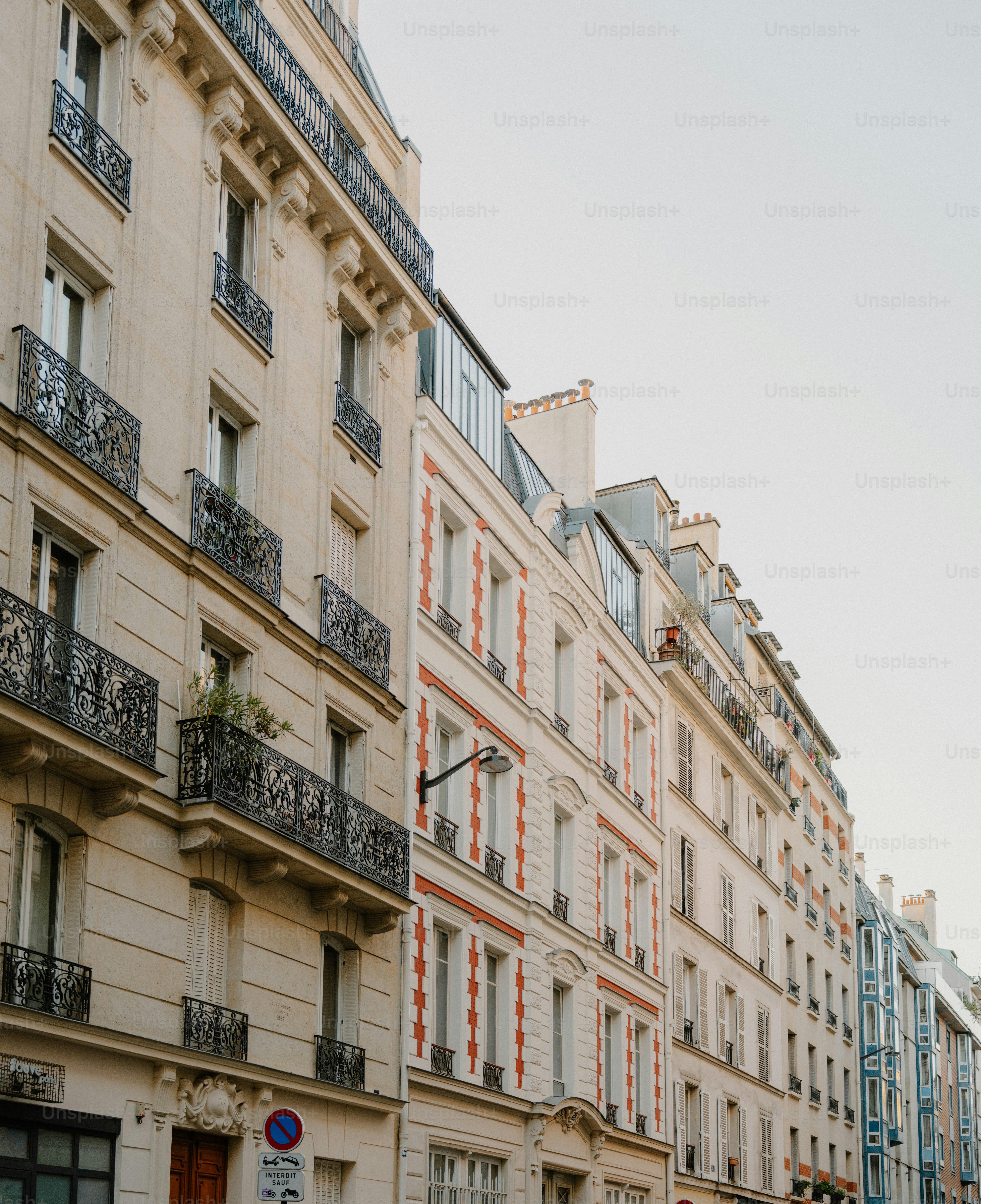 Row of classic parisian apartment buildings under a clear sky.
