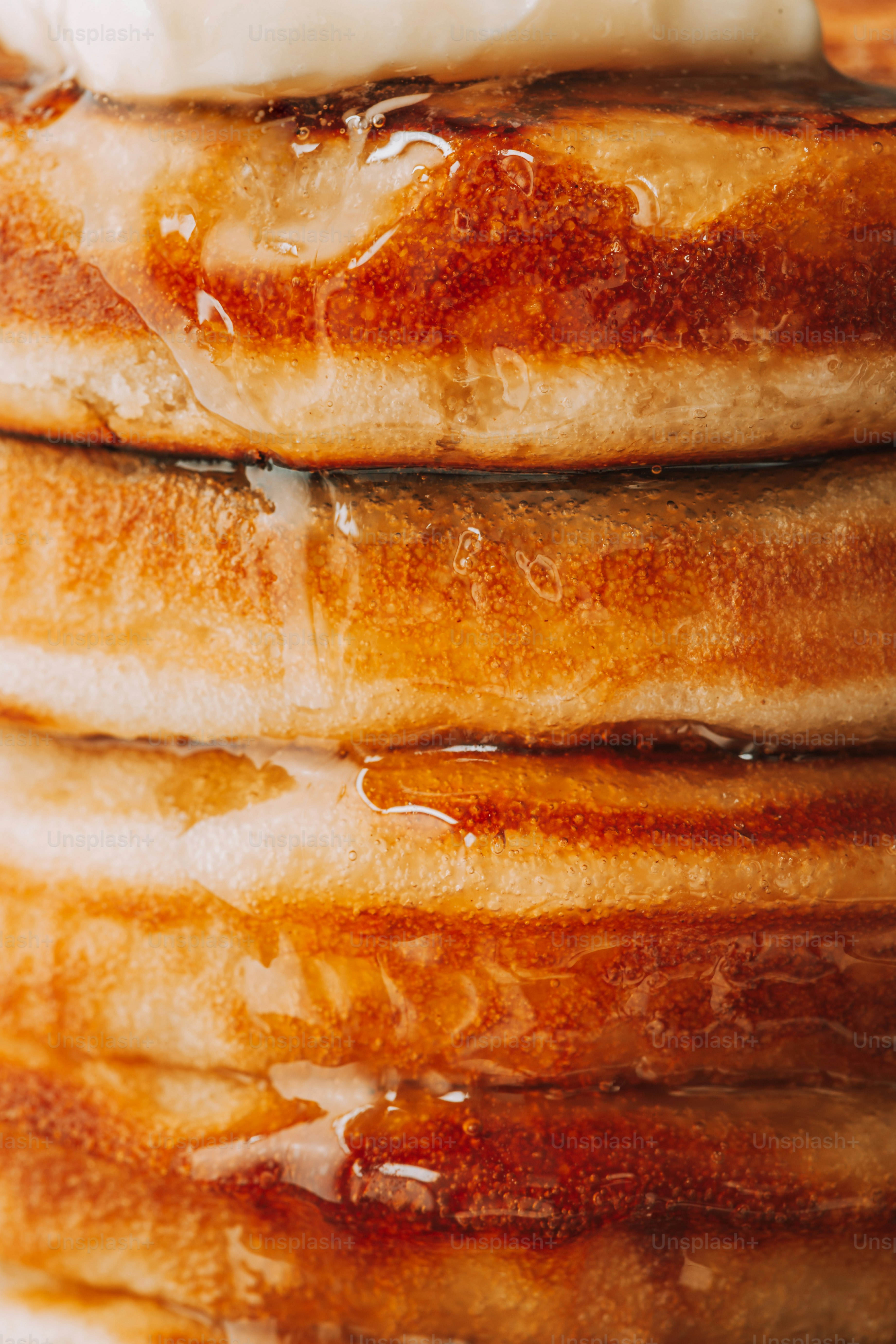 Stack of fluffy pancakes with syrup and butter
