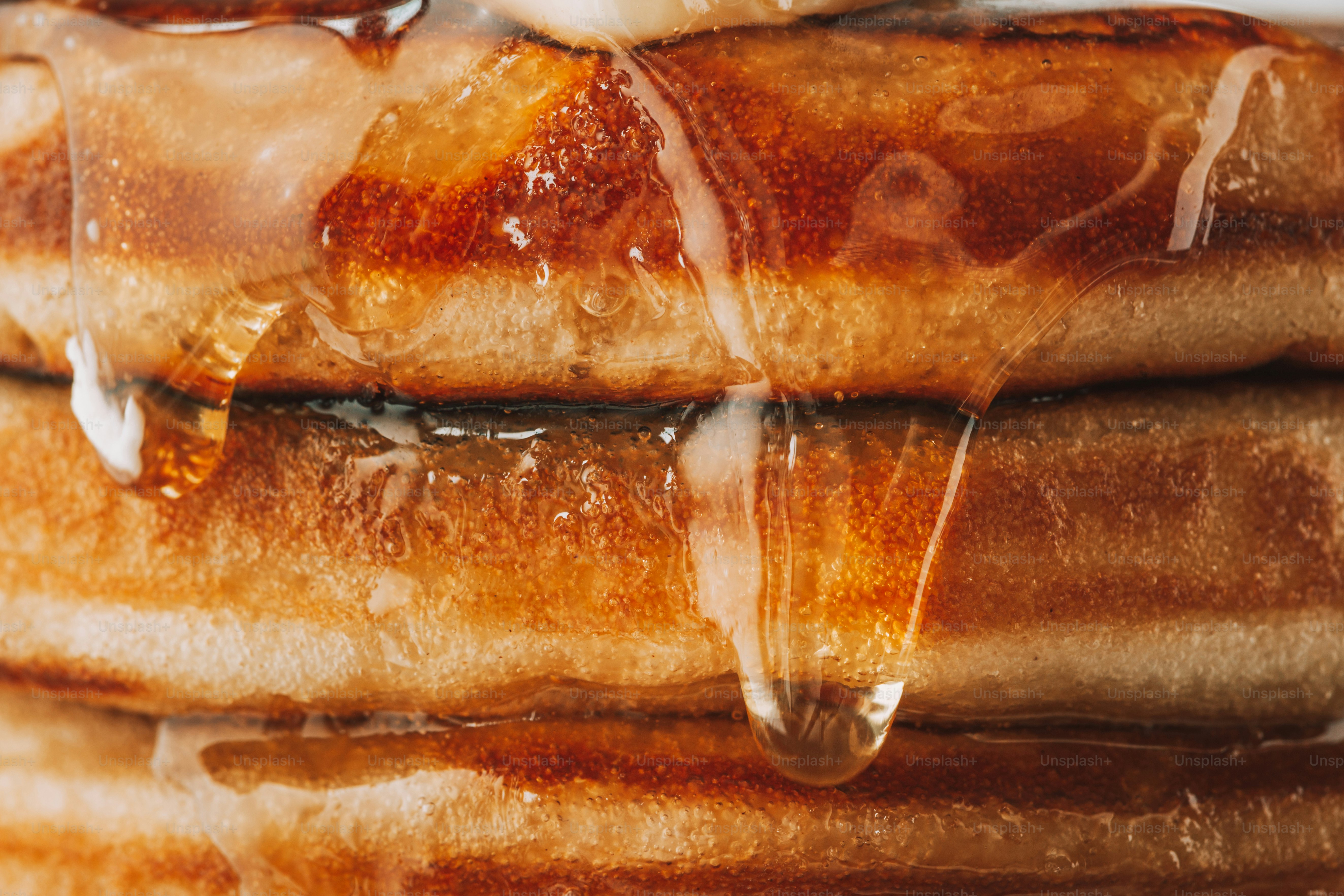 Stack of golden waffles with dripping syrup