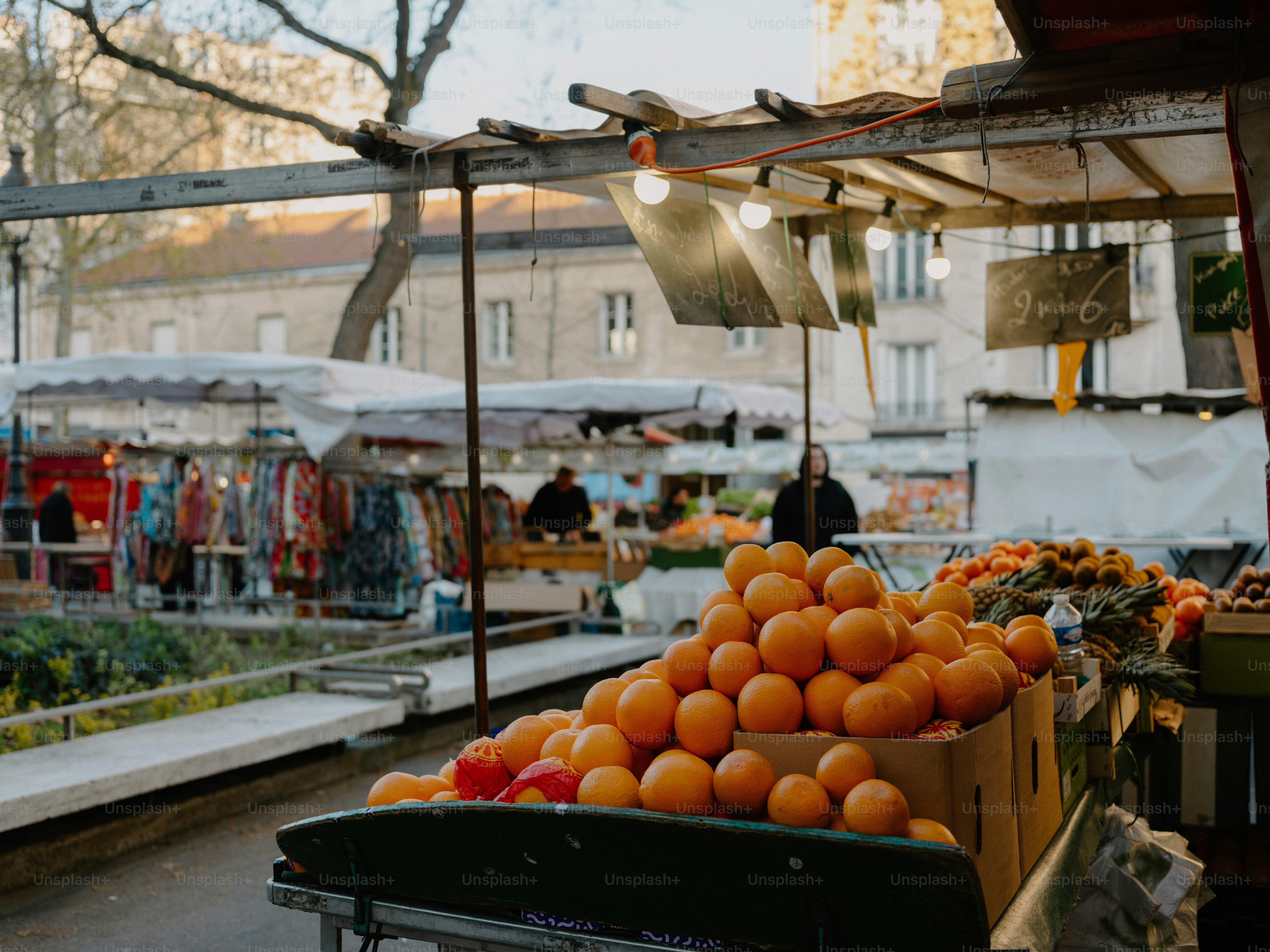 People at an outdoor market with trees and stalls. photo – Shopping ...