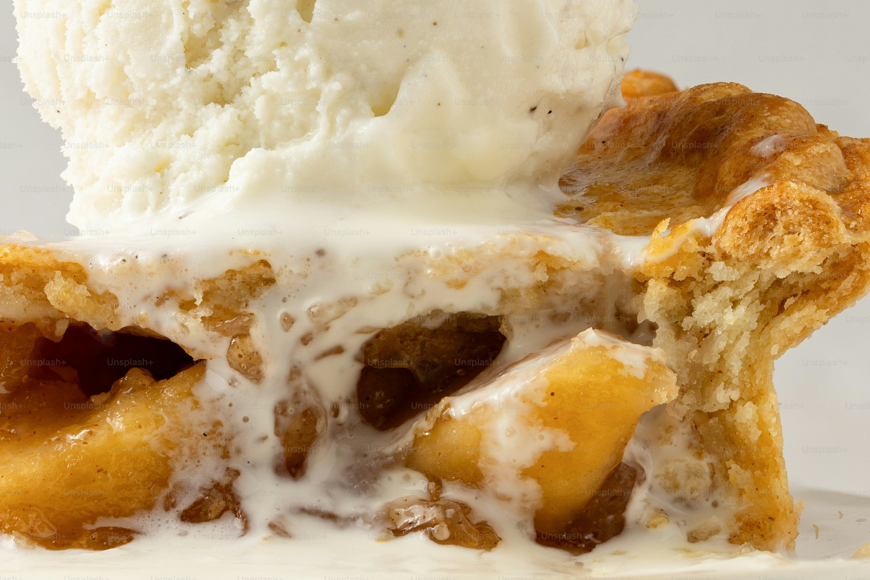 Slice of apple pie with melting vanilla ice cream