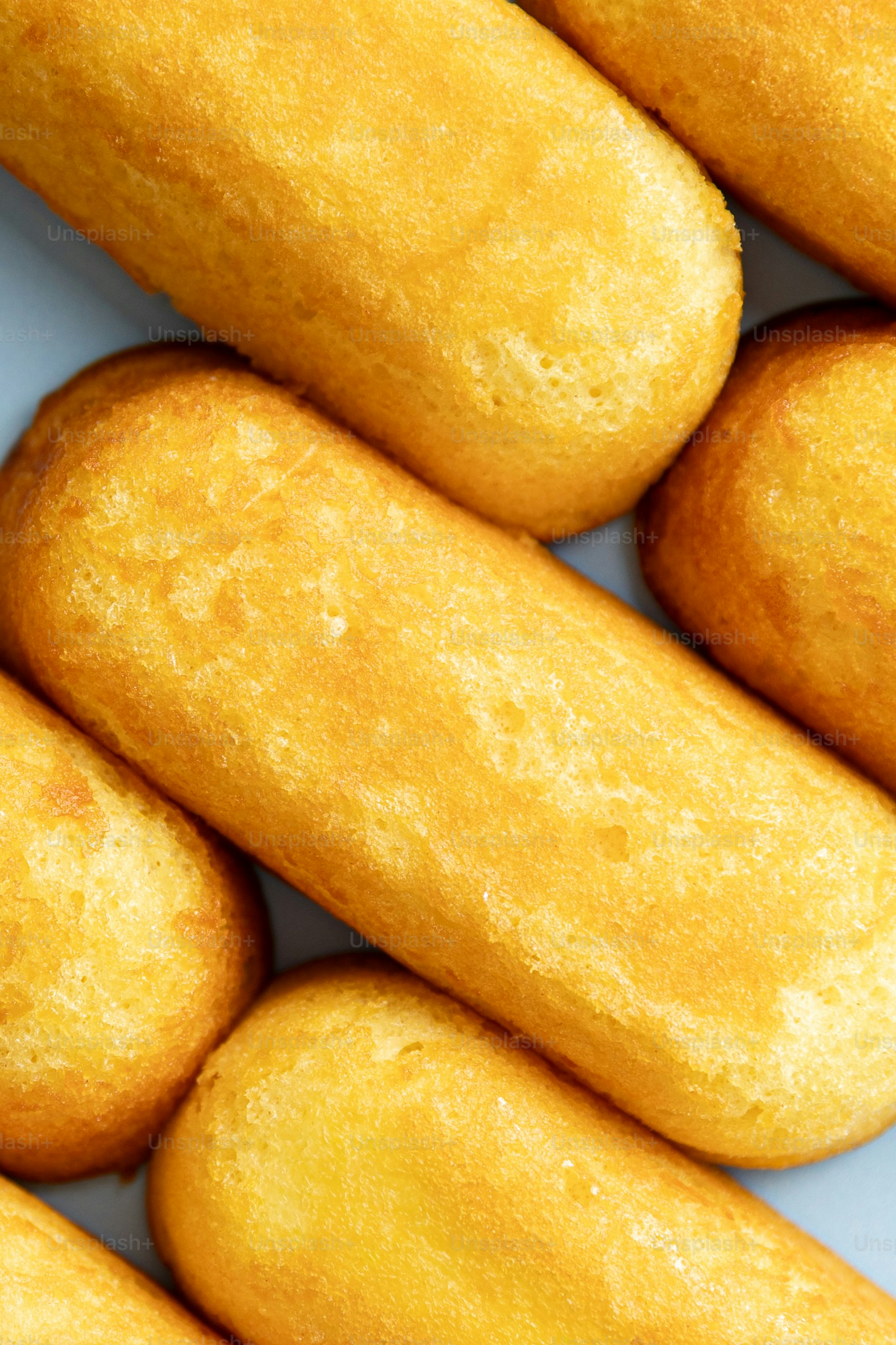 Golden sponge cakes arranged diagonally on a blue surface