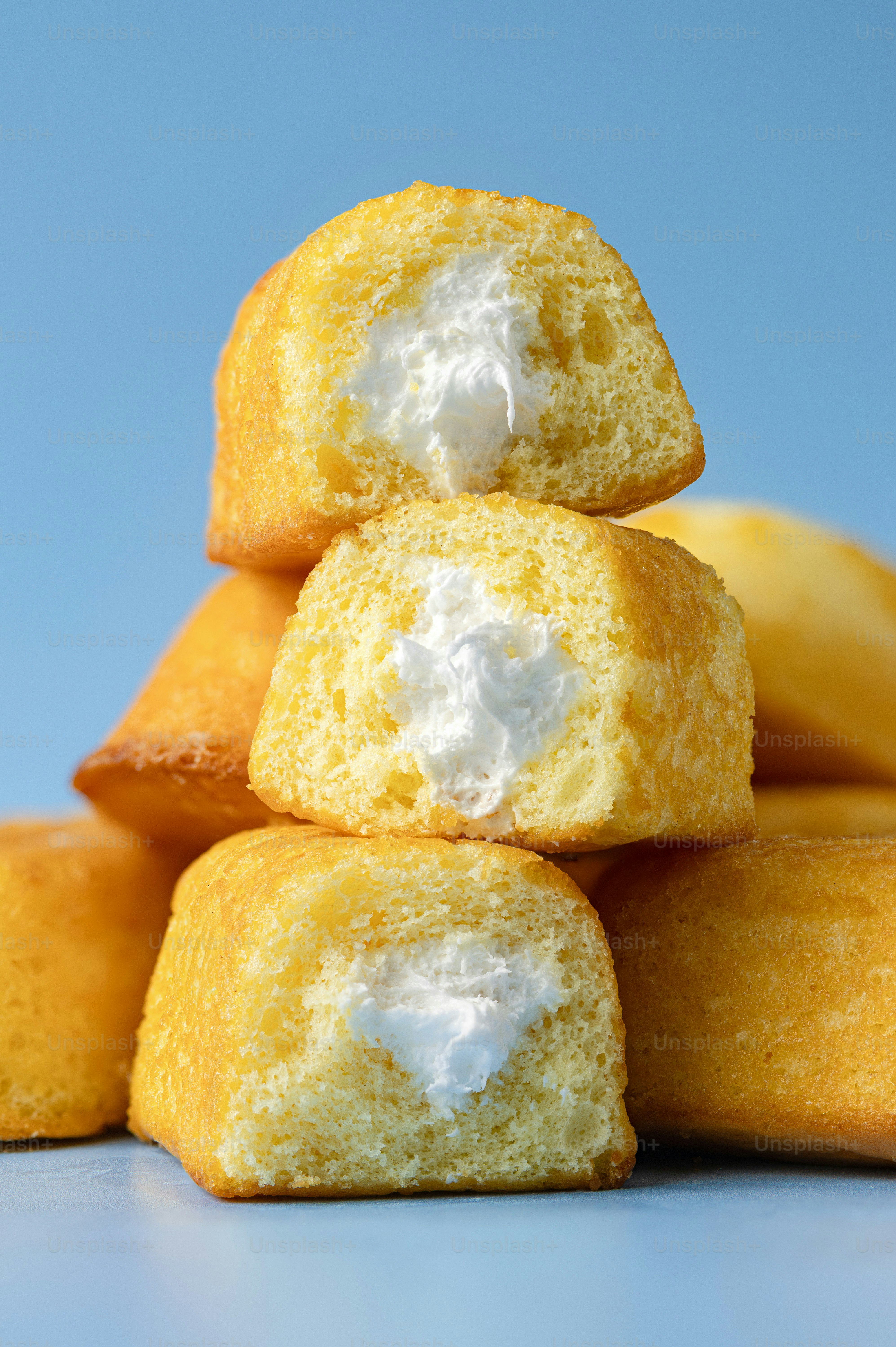 Stack of cream-filled snack cakes on blue background