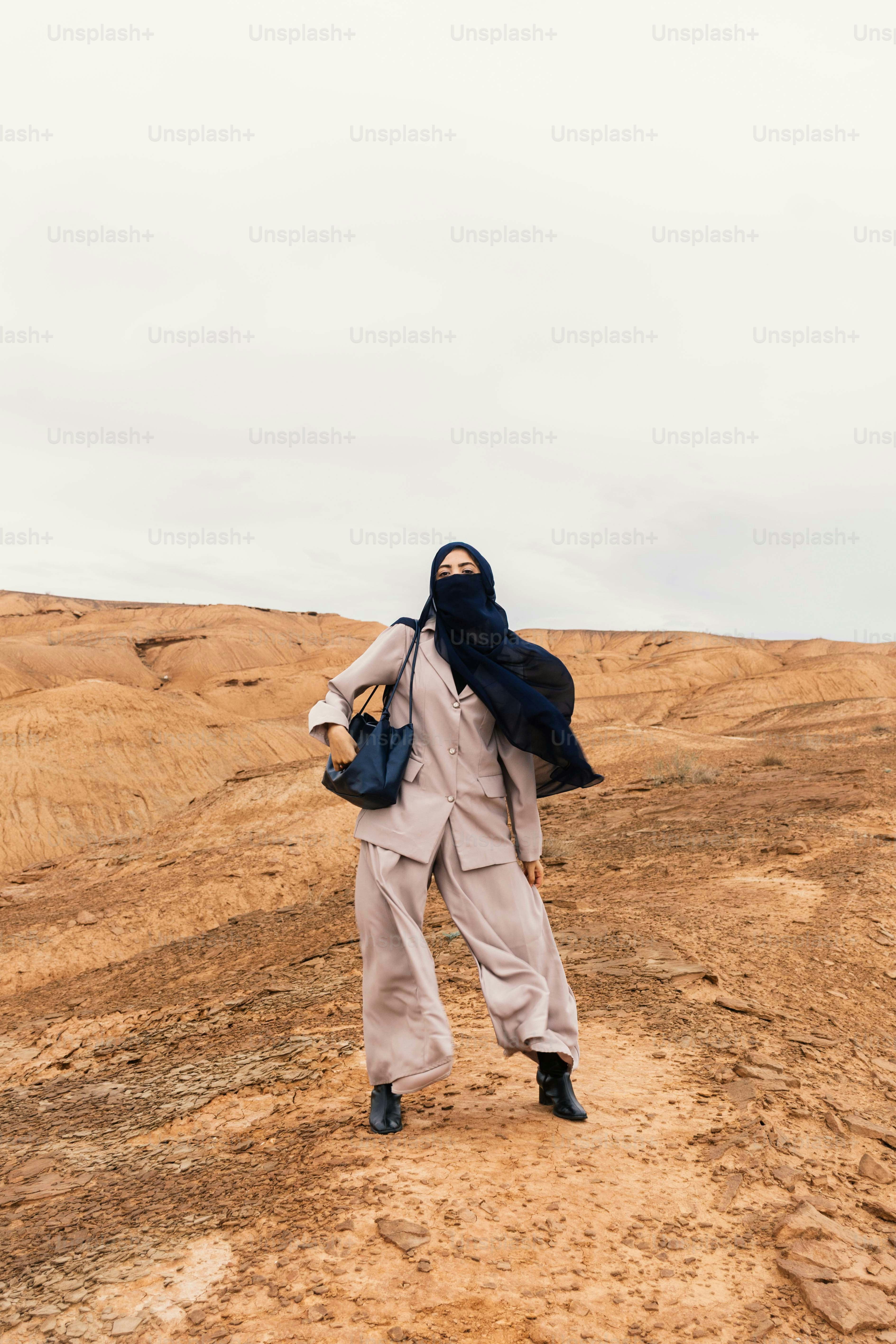 Femme en hijab et tenue stylée dans un paysage désertique