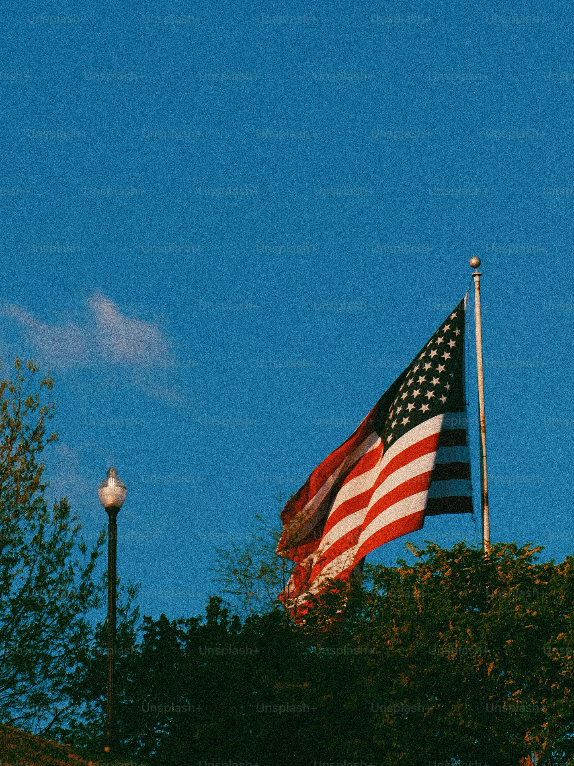 American flag waving against a clear blue sky