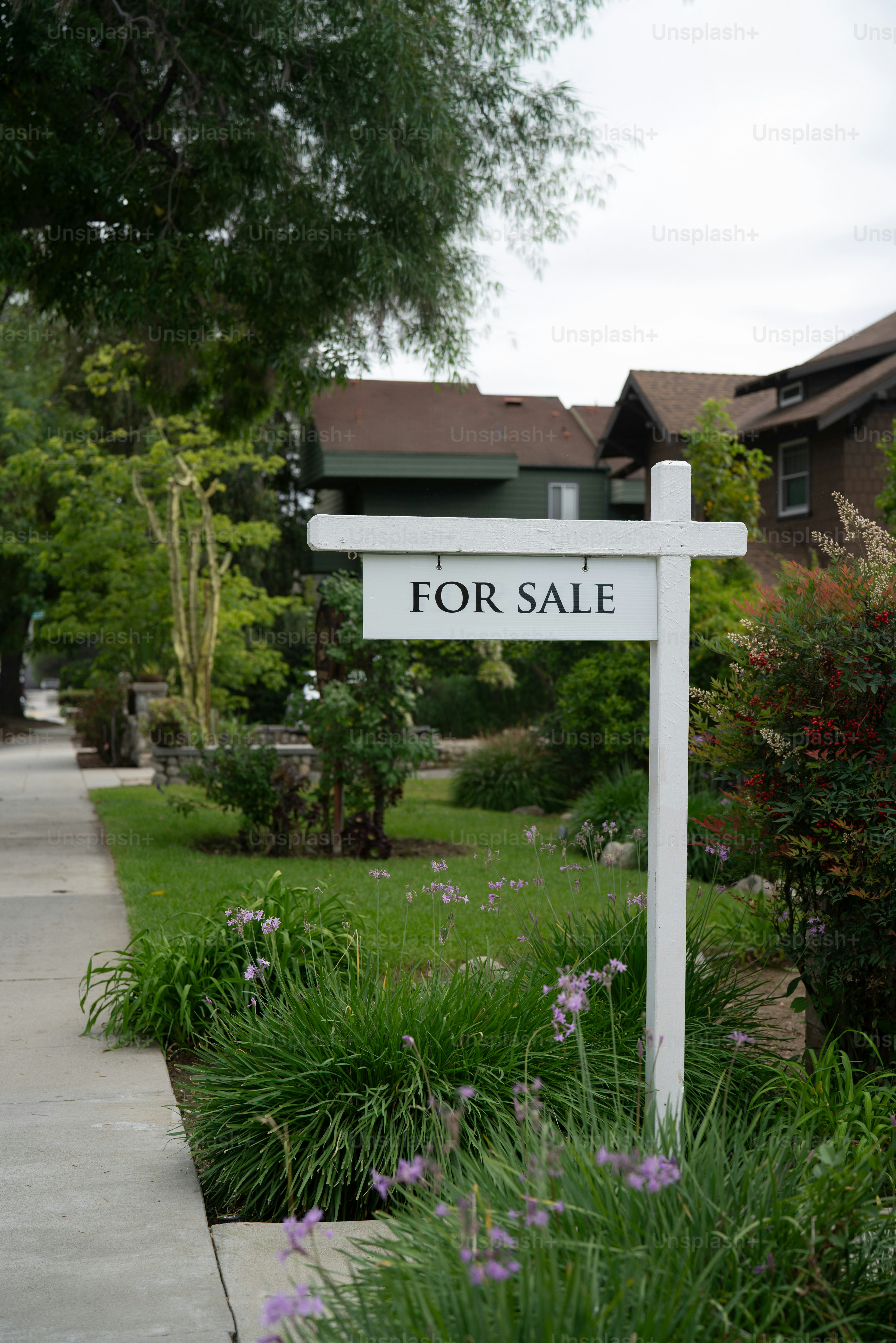 White for sale sign in front of a house