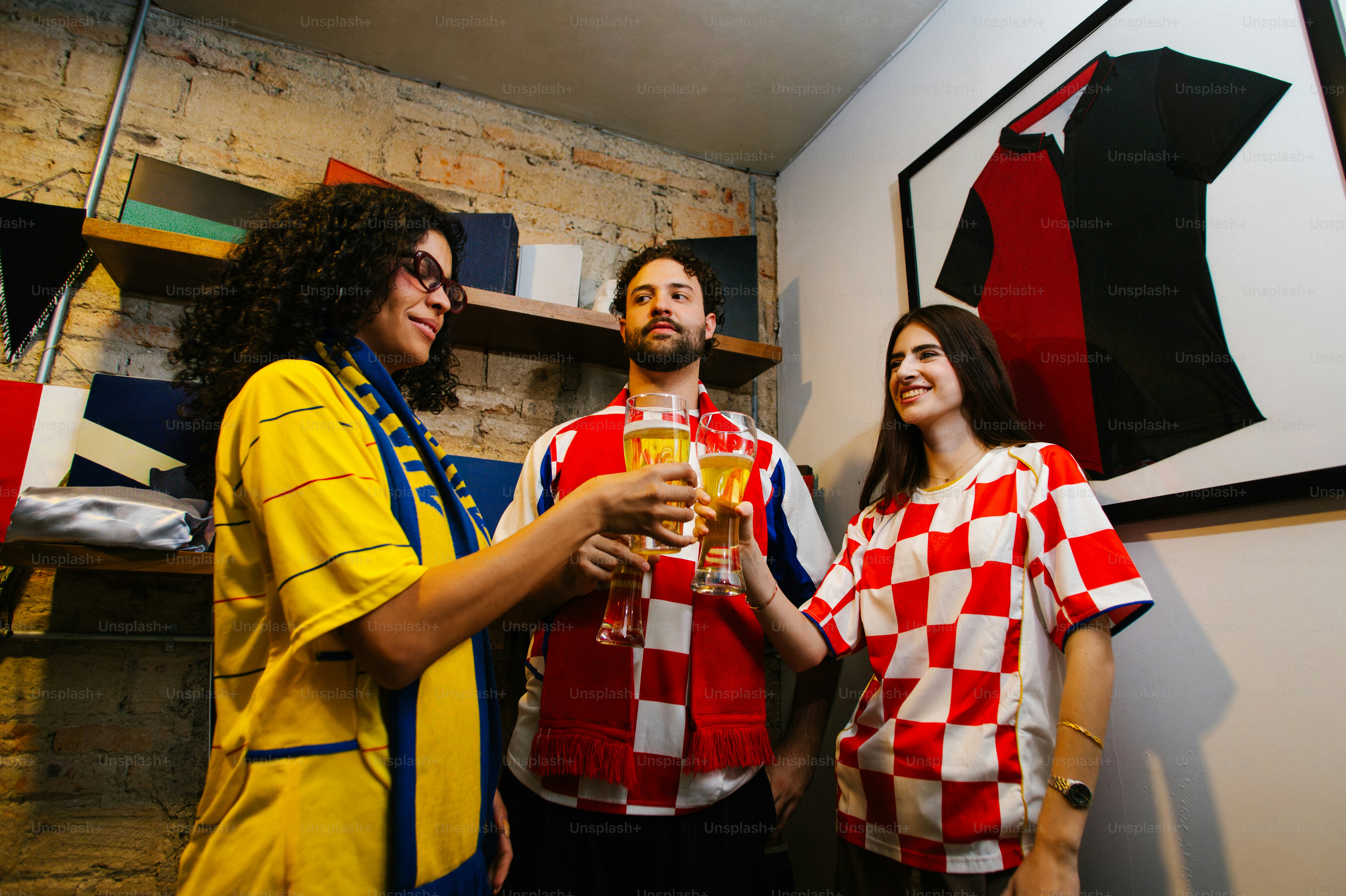 Tre amici in maglie che brindano con birra