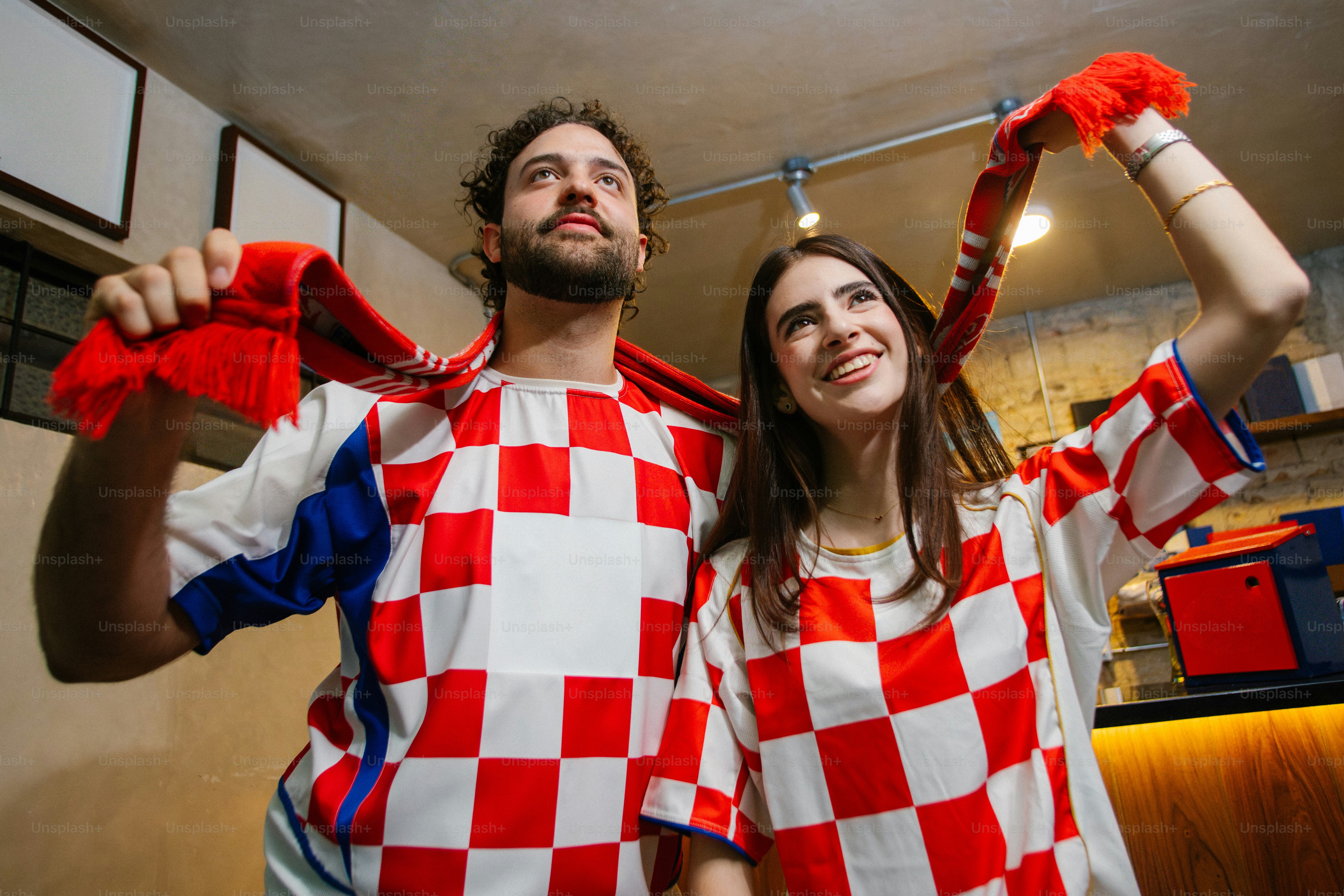 Coppia che indossa maglie e sciarpe con la bandiera croata