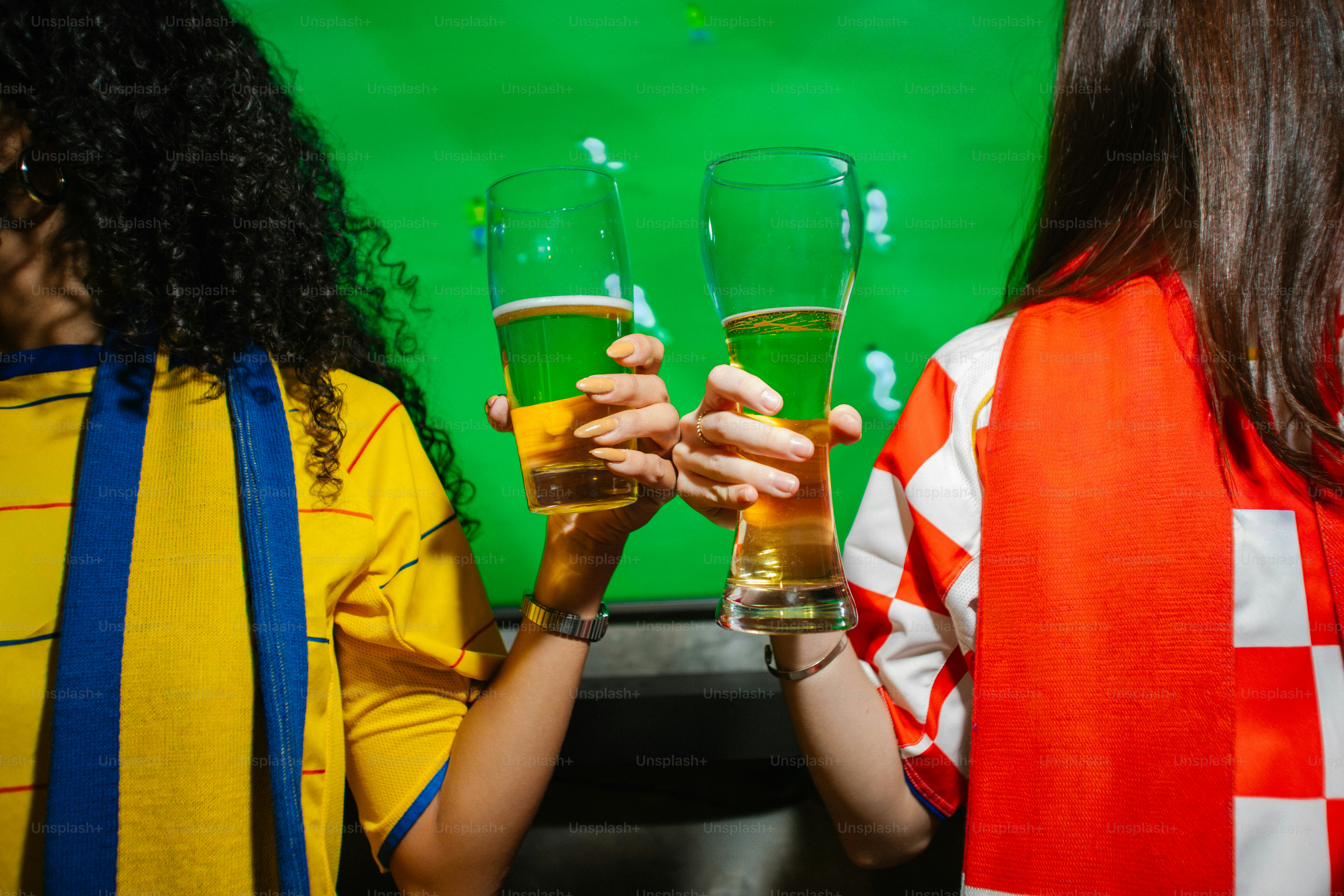 Due persone con maglie sportive che brindano con la birra.