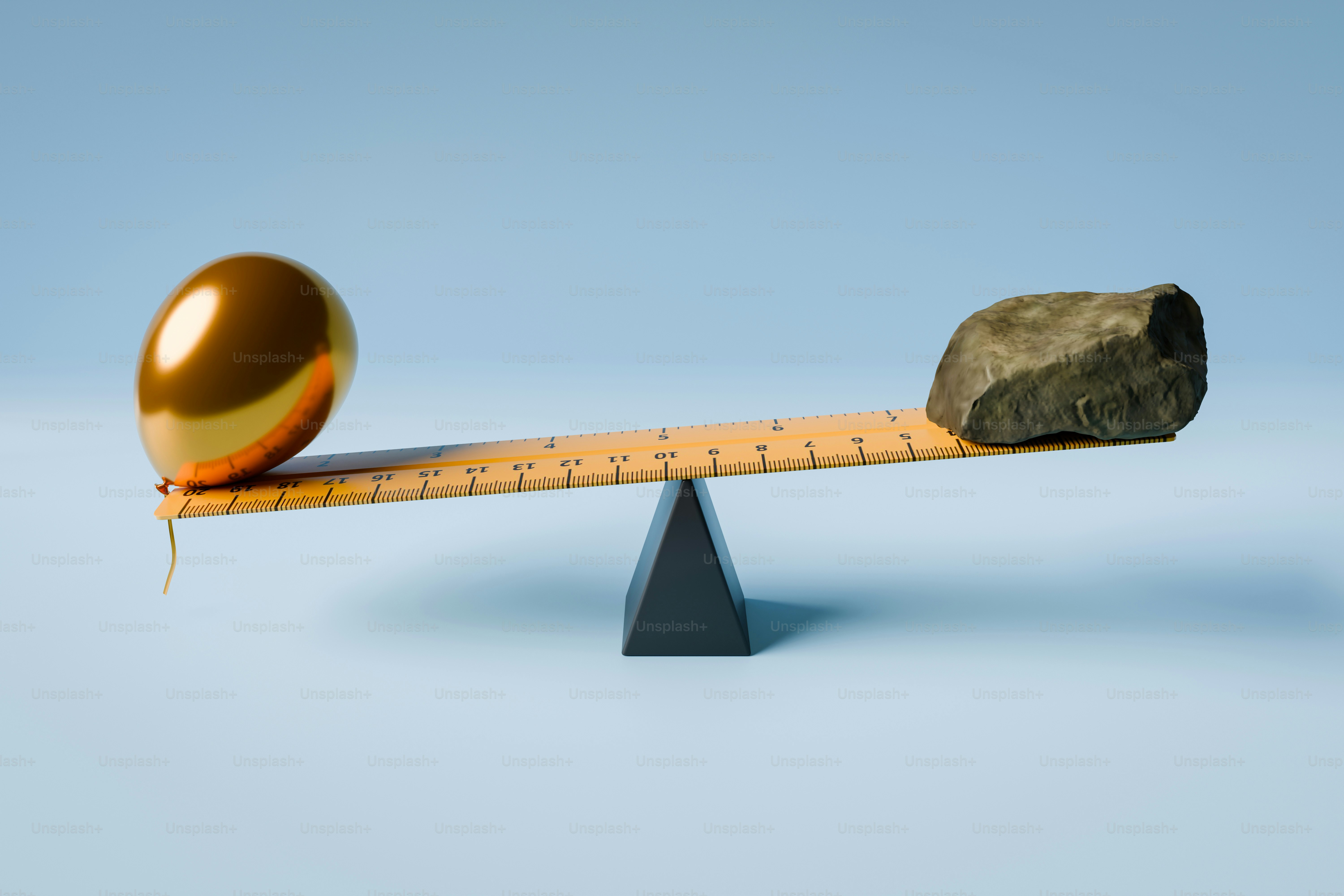 Un globo dorado y una piedra en un balancín