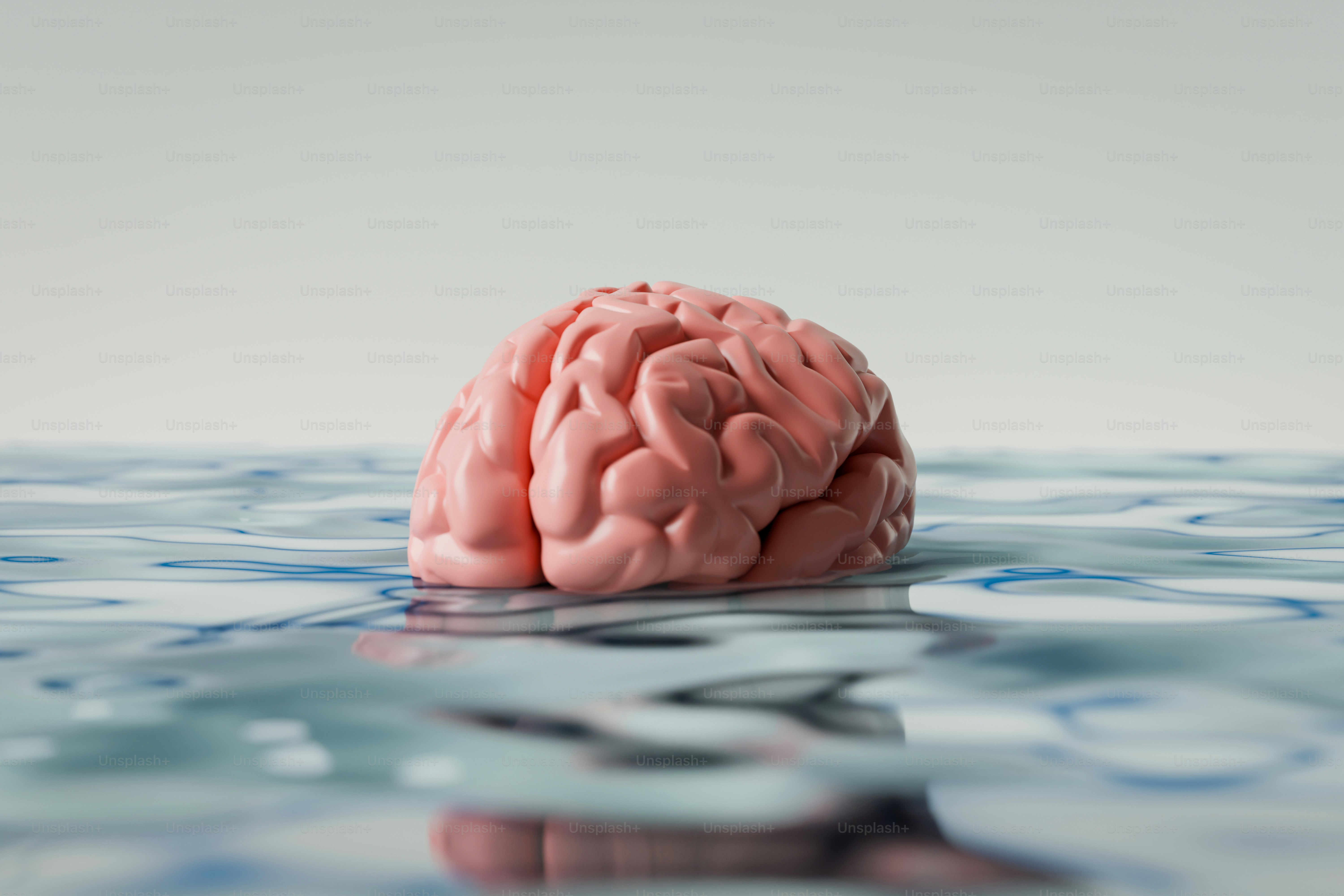 Un cerebro rosado flota sobre el agua azul ondulante.