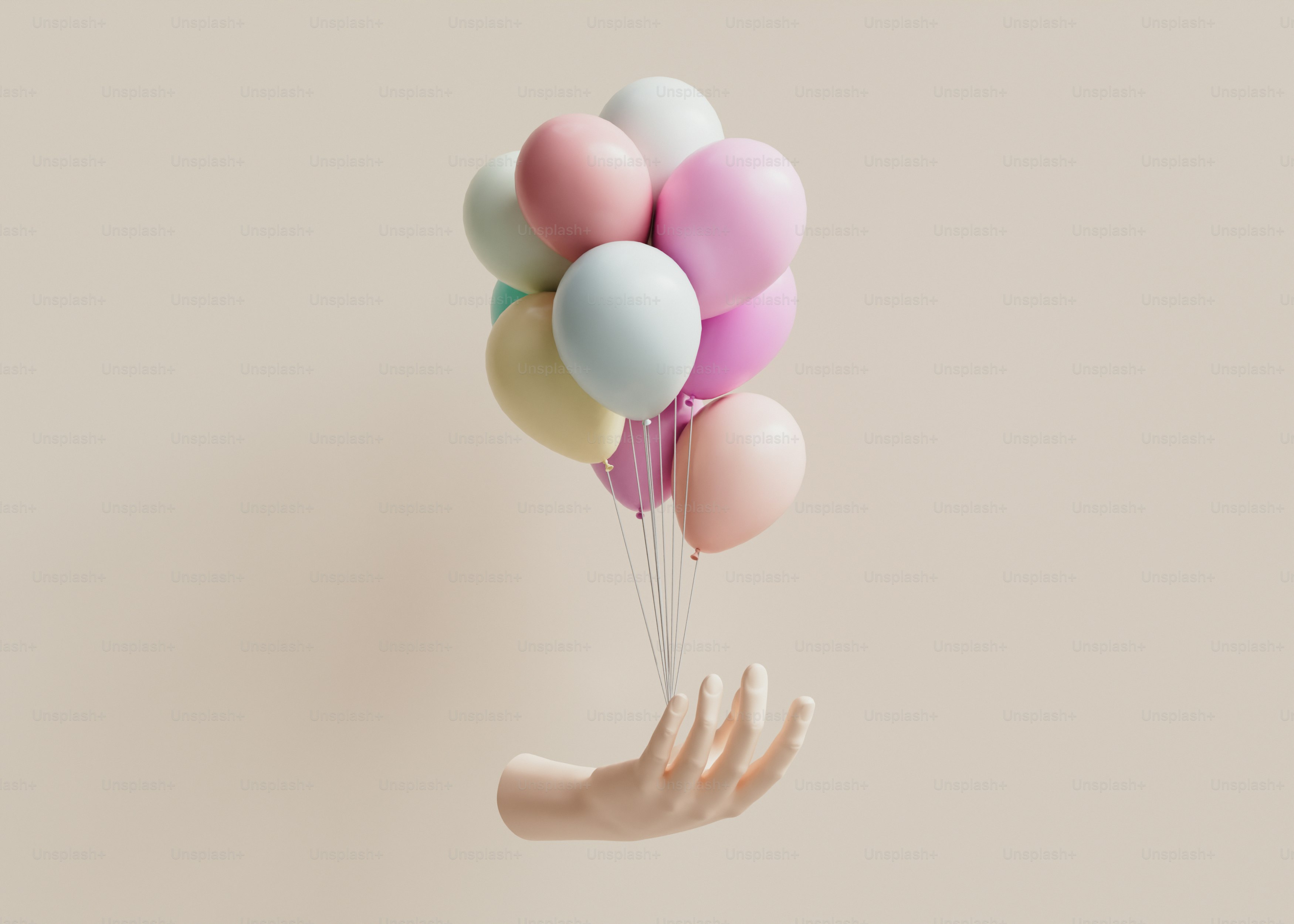 Una mano che tiene un mucchio di palloncini pastello