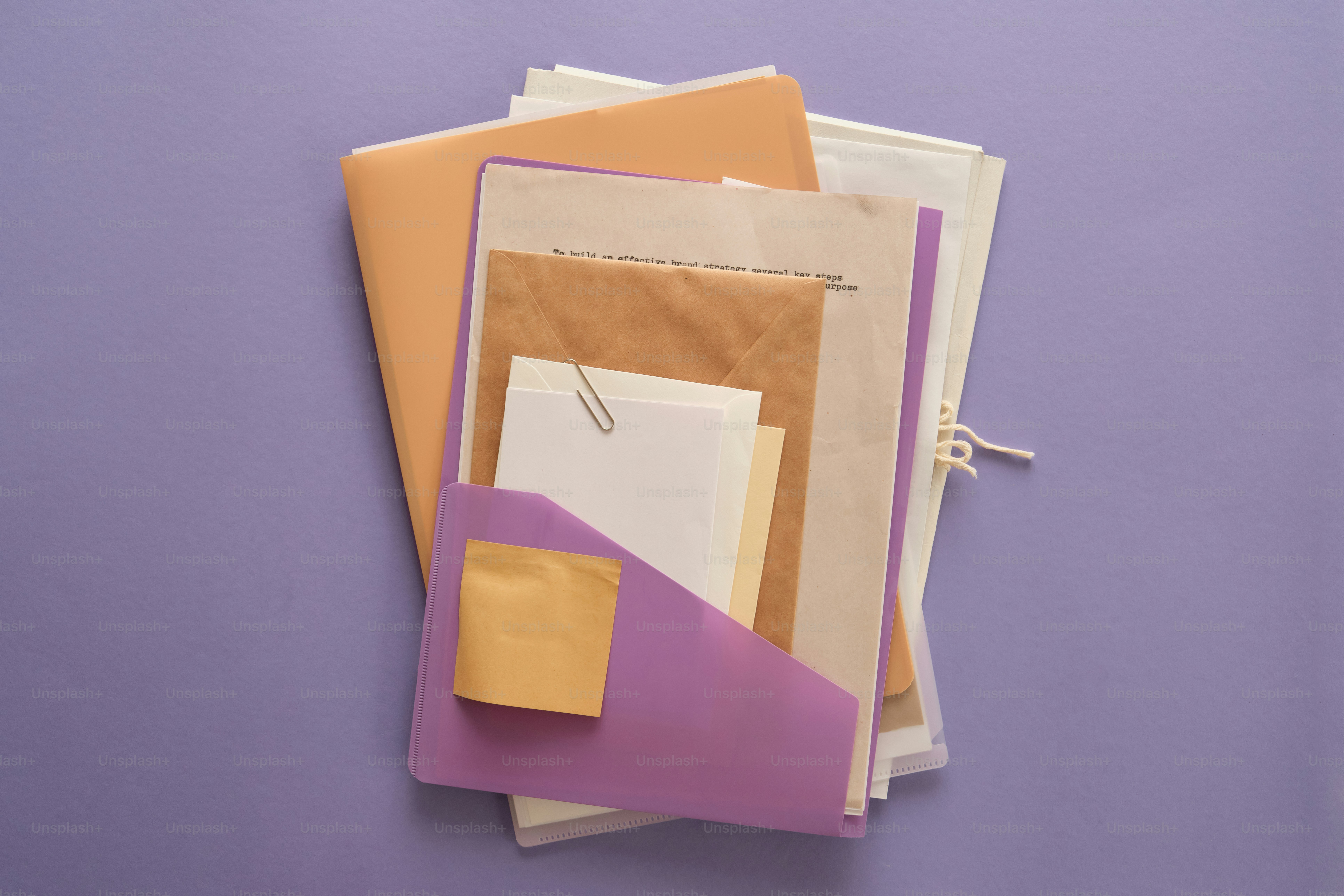 A stack of papers and envelopes on a purple background photo – Minimal ...