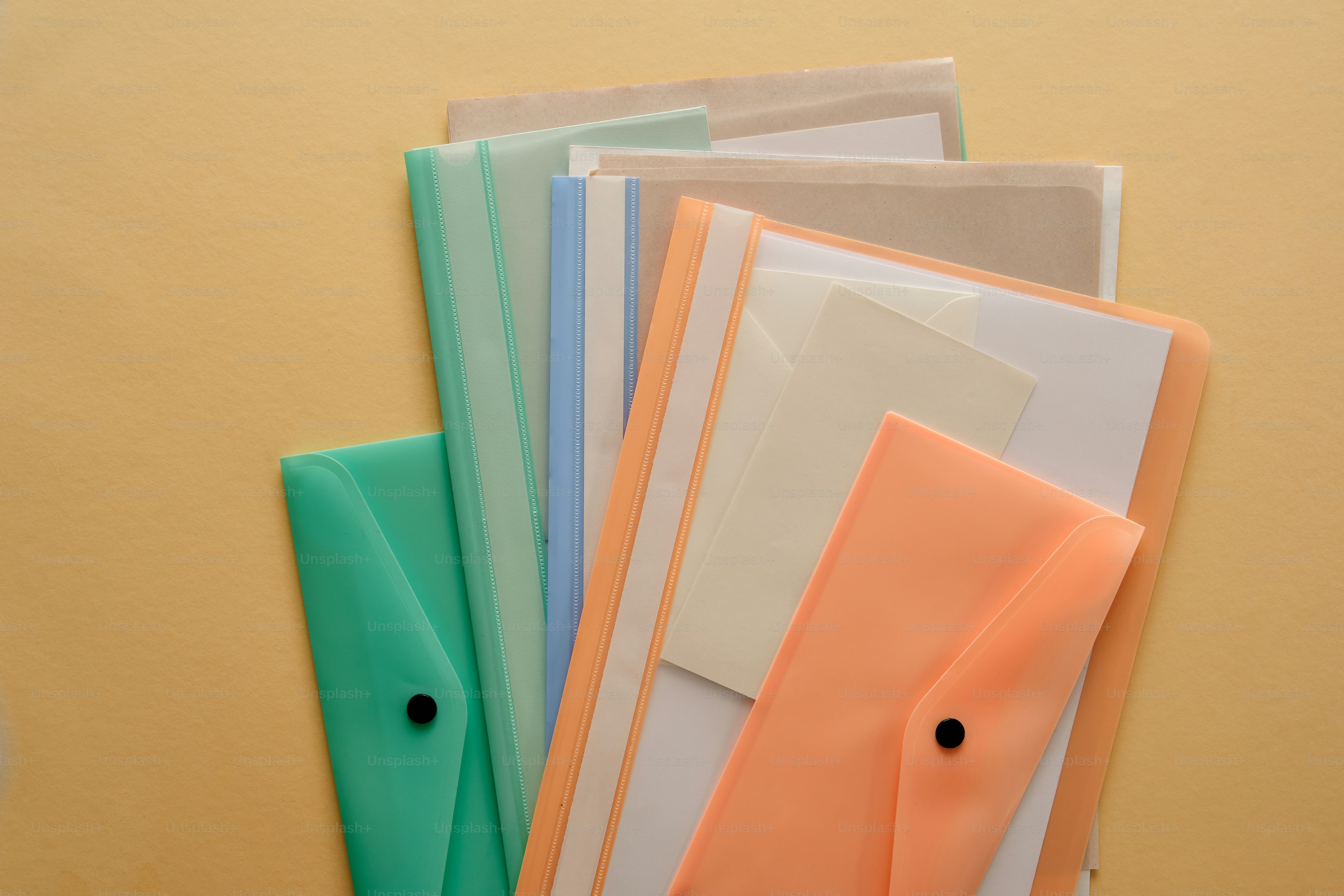 Assortment of colorful document folders on a peach background photo ...
