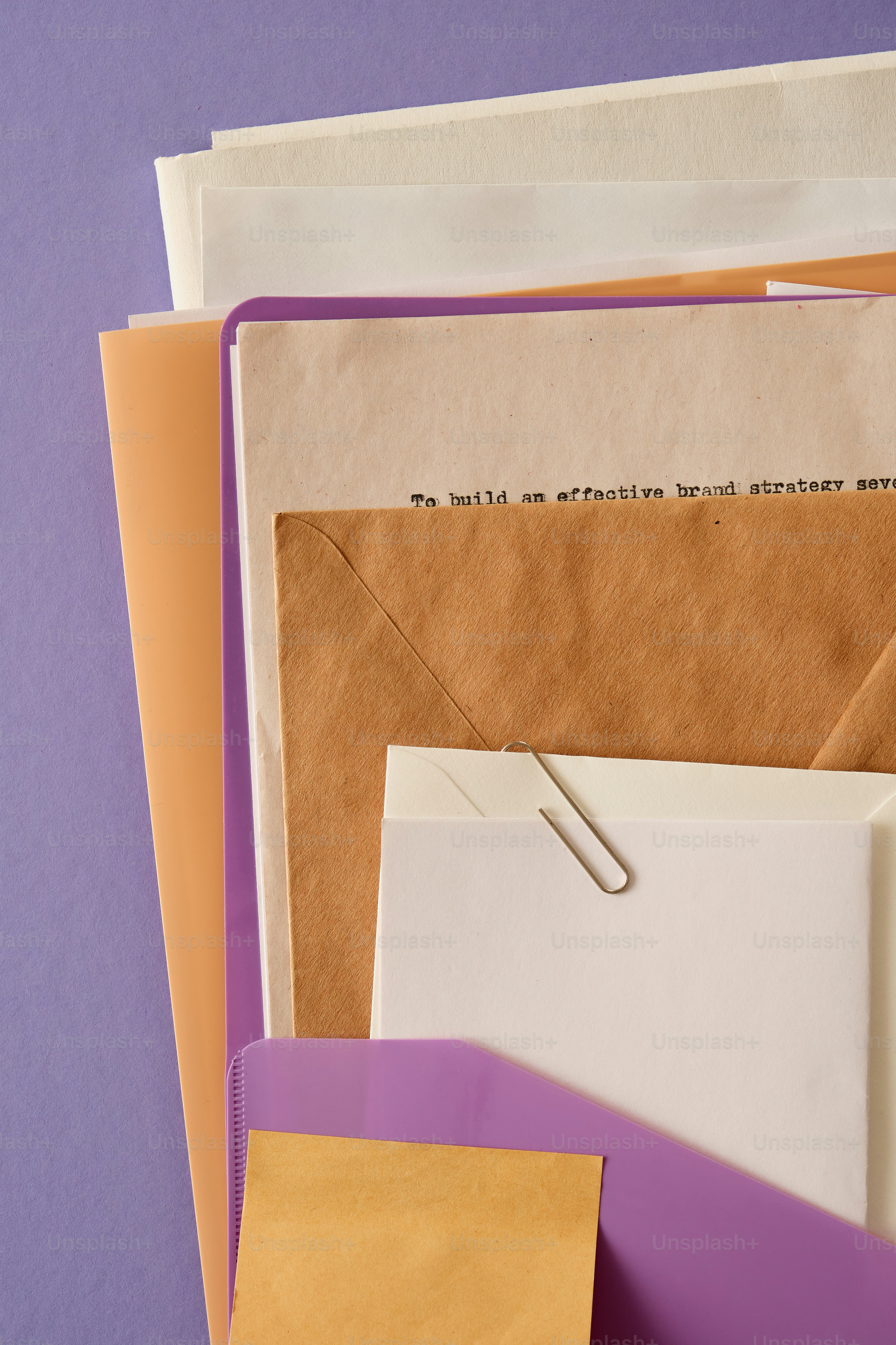 A stack of papers and envelopes on a purple background photo – Minimal ...
