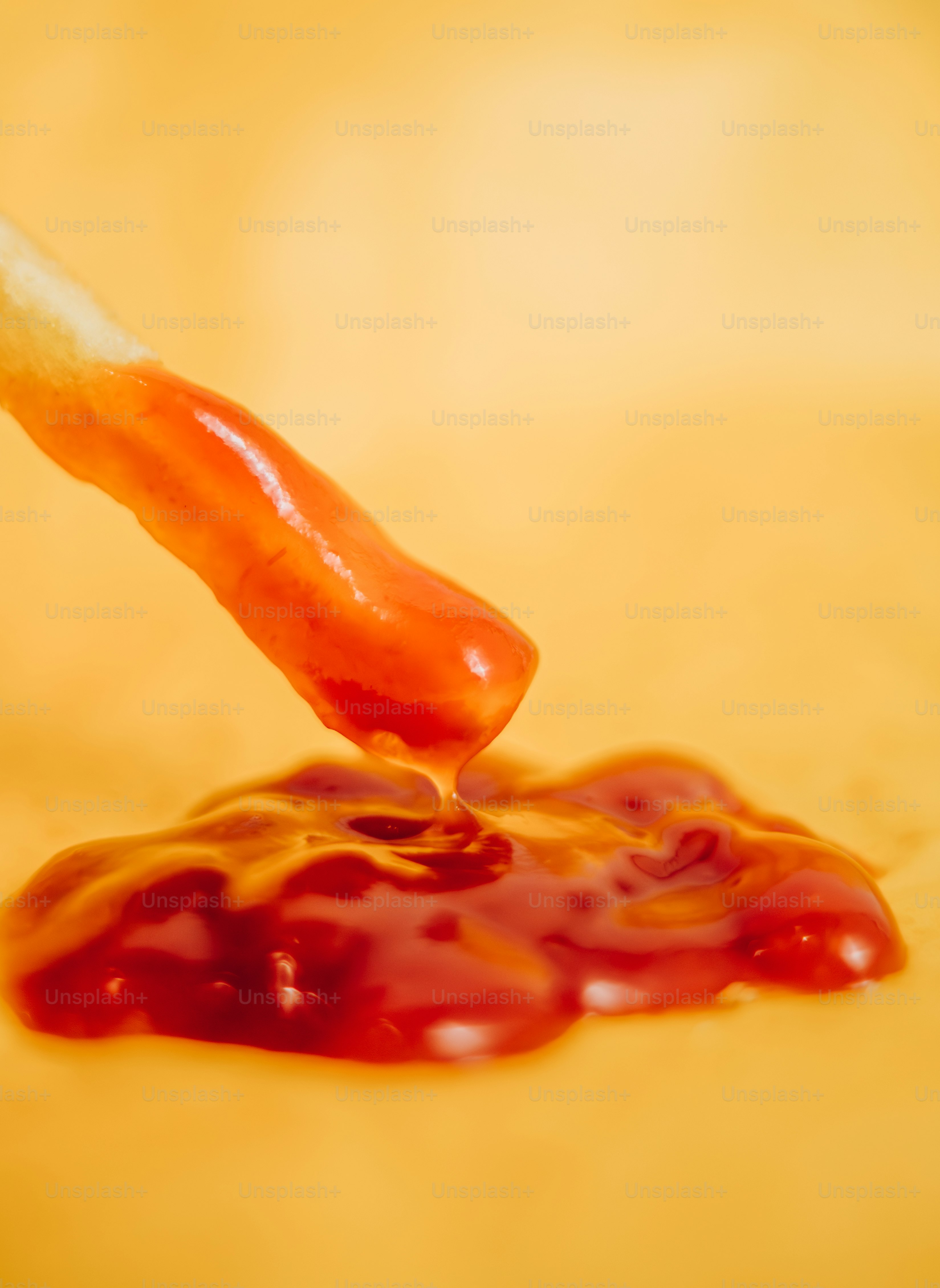 A french fry is dipped into a puddle of ketchup. photo – Fast food ...