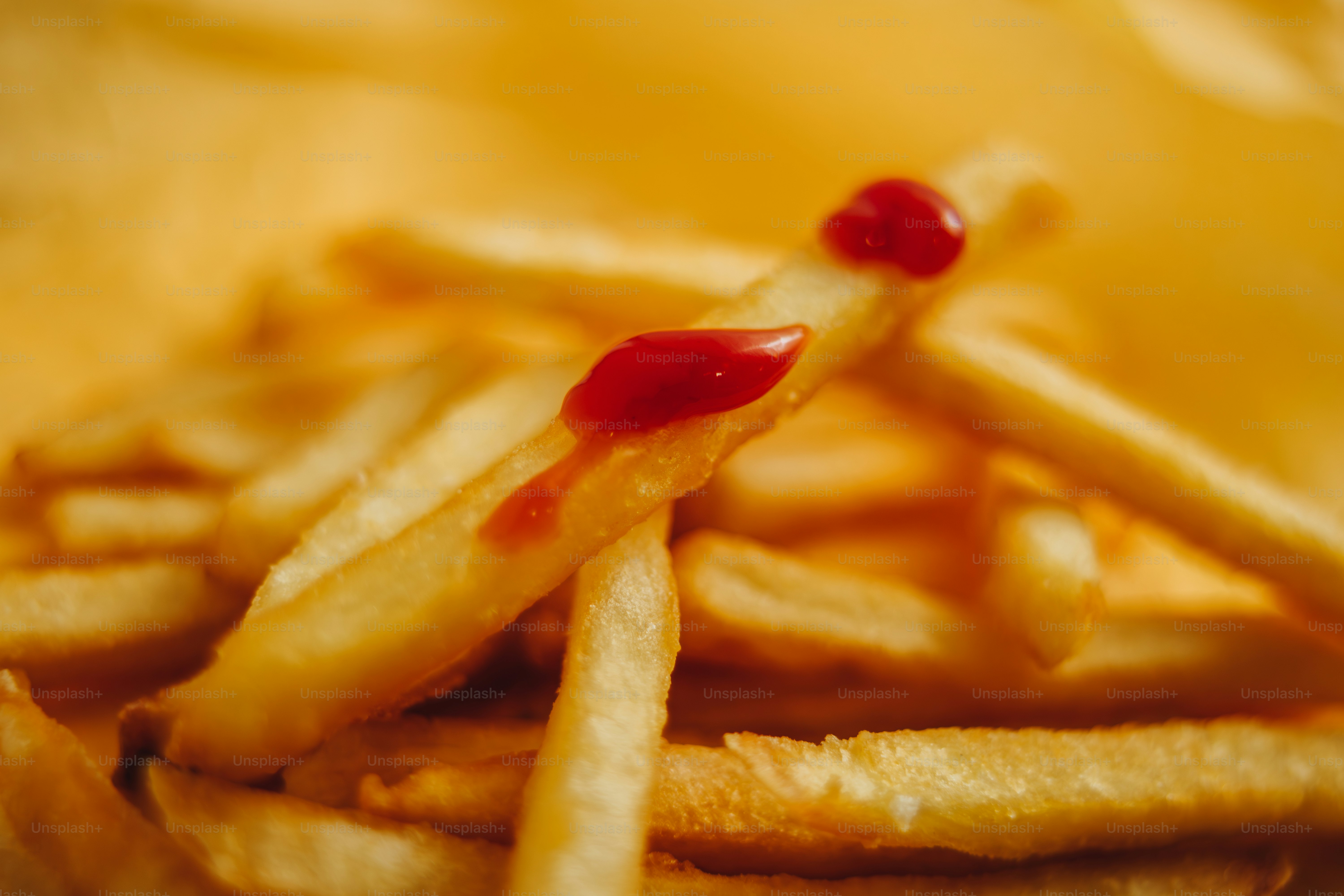 A french fry is dipped into a puddle of ketchup. photo – Fast food ...