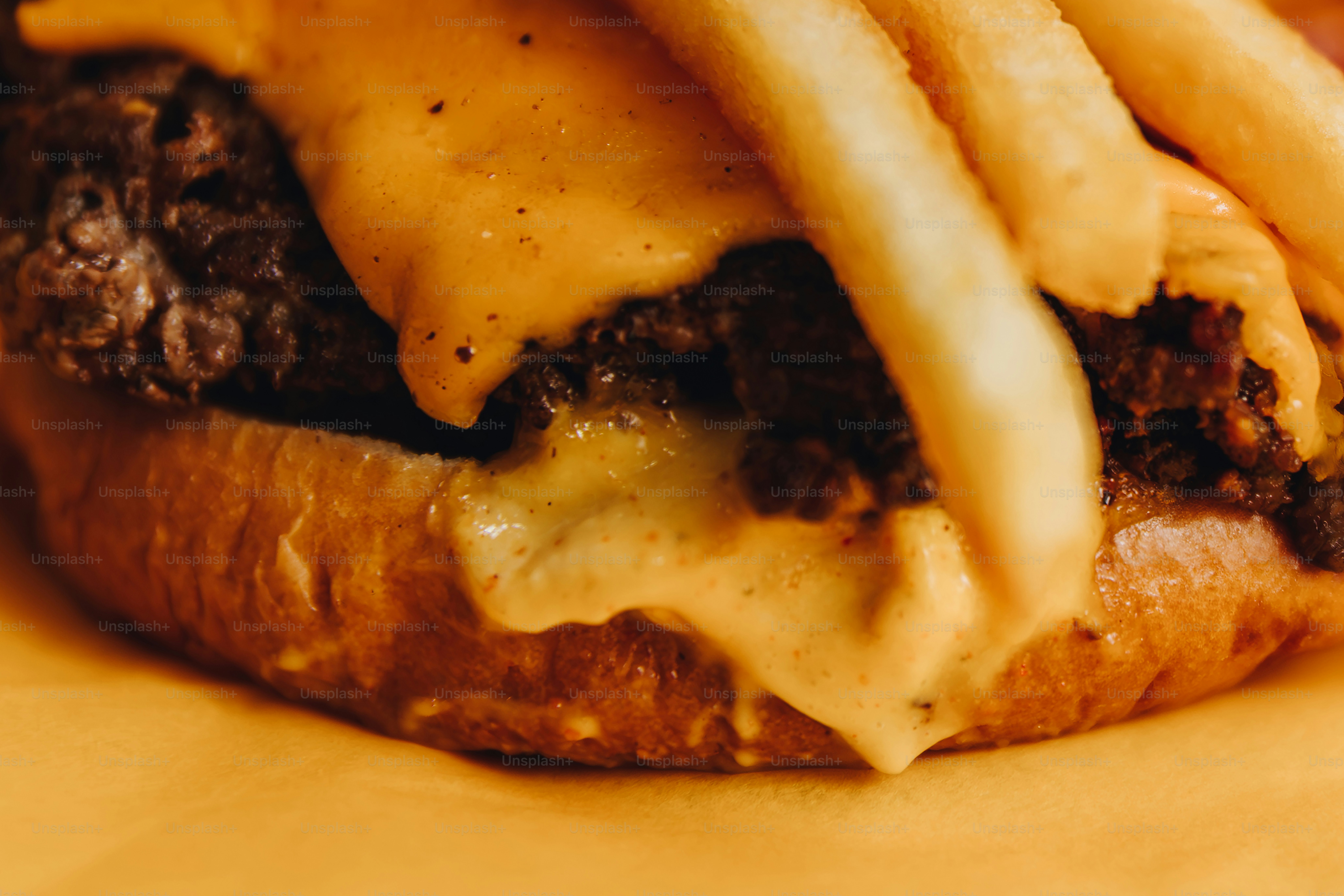 Hamburger al formaggio con patatine fritte su sfondo giallo