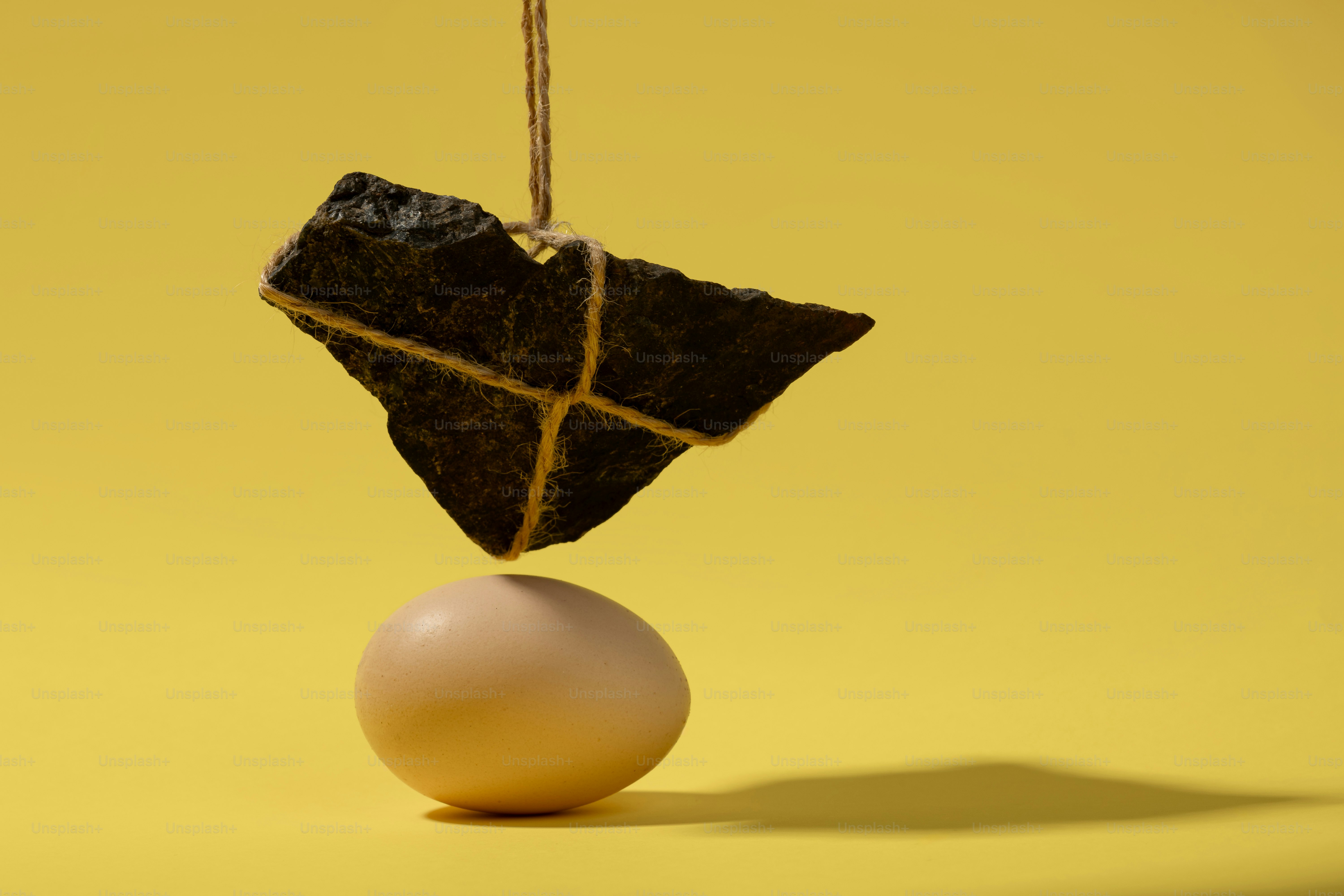 Una piedra atada con cuerda equilibrada sobre un huevo.