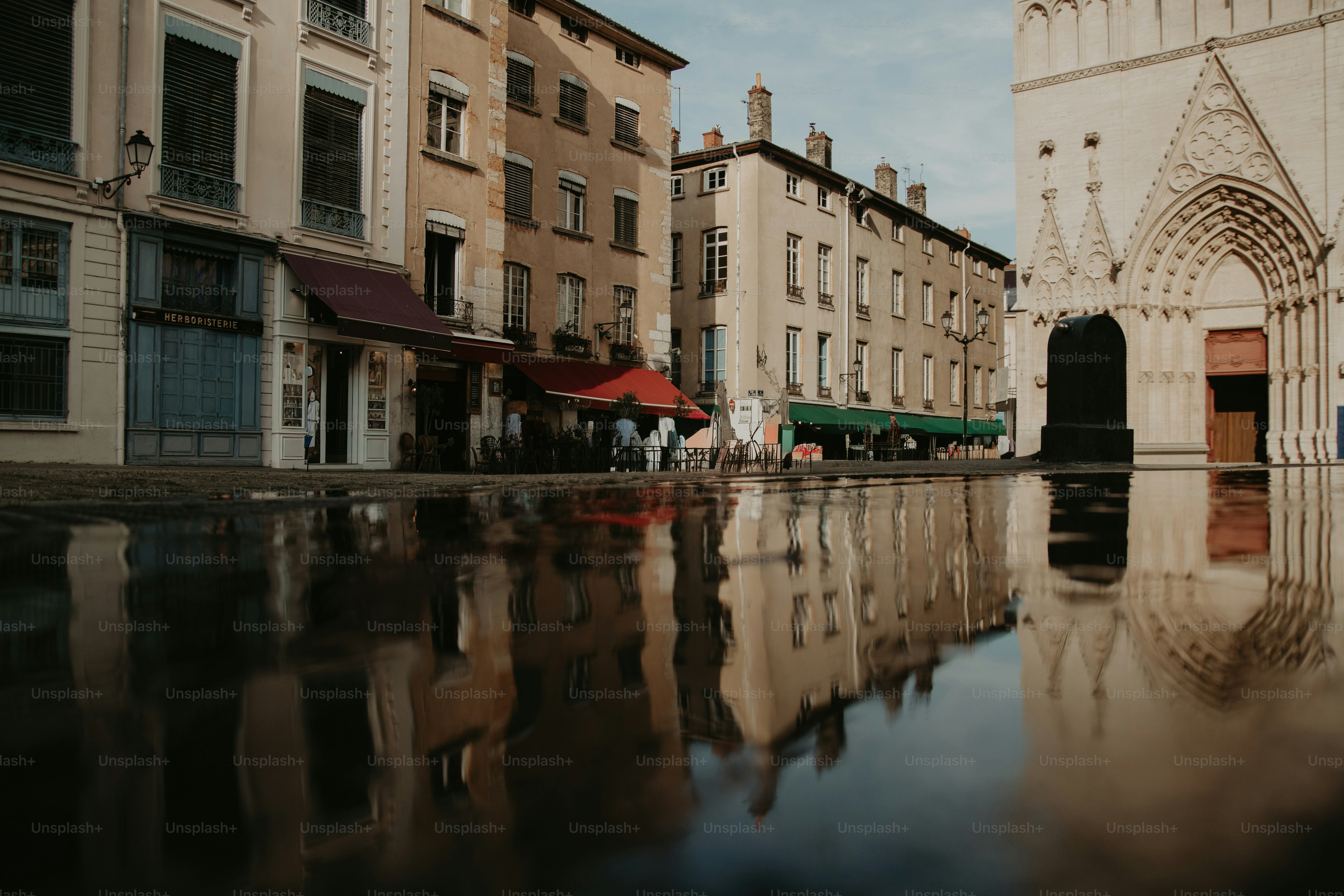 Bangunan tercermin di alun-alun kota yang basah