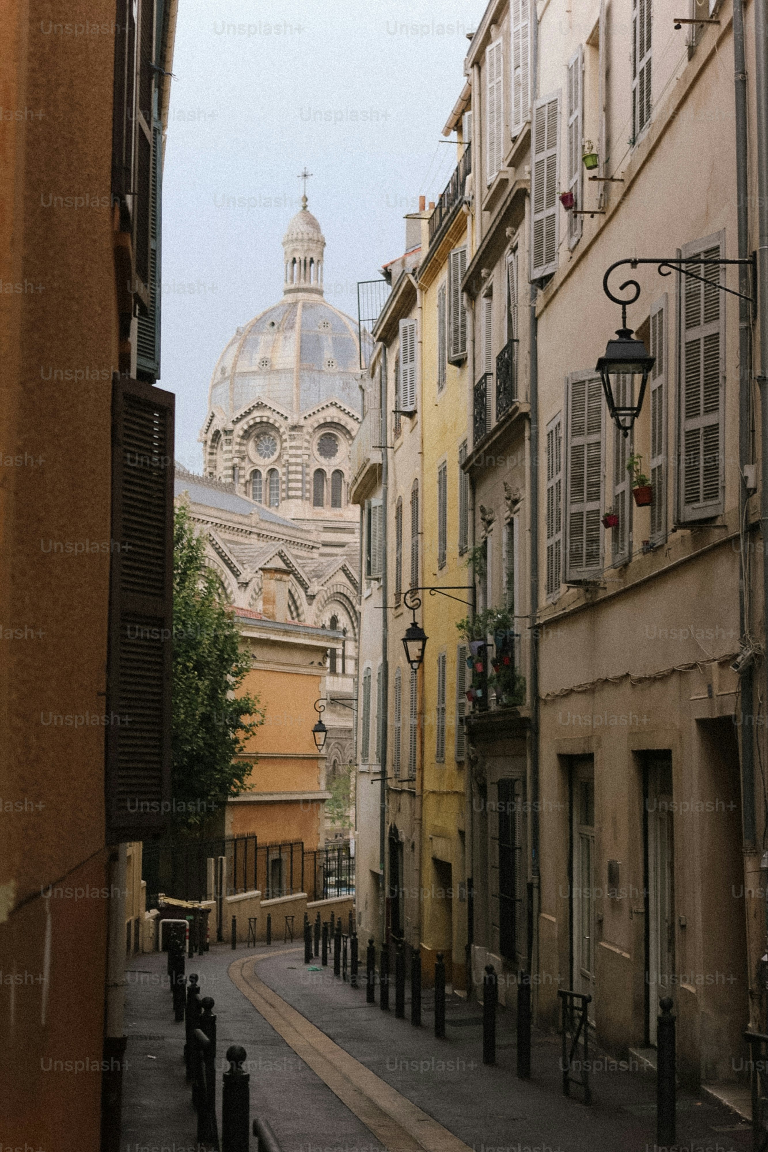 Rua estreita com prédios e uma catedral com cúpula