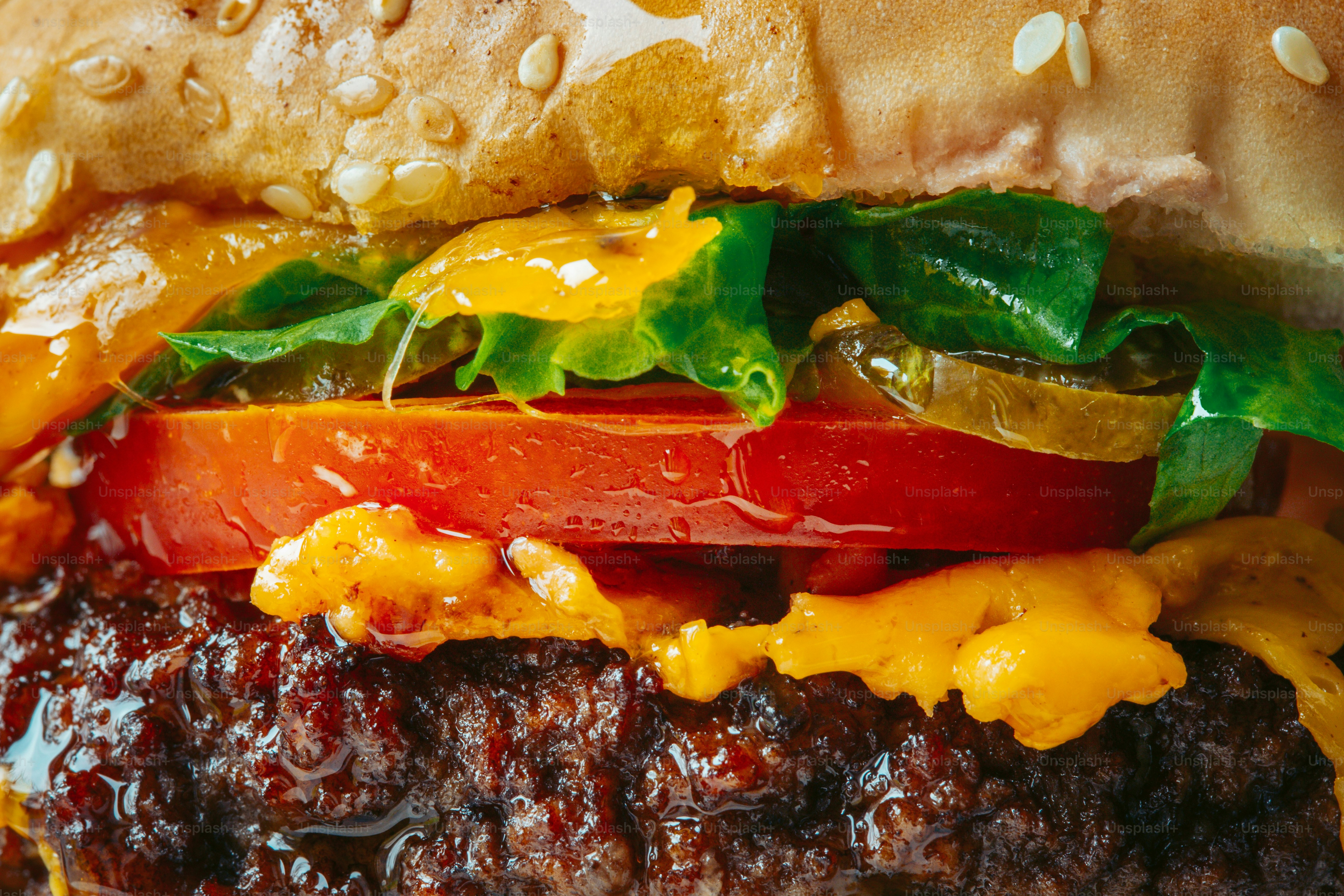 A juicy cheeseburger with lettuce, tomato, and pickles.