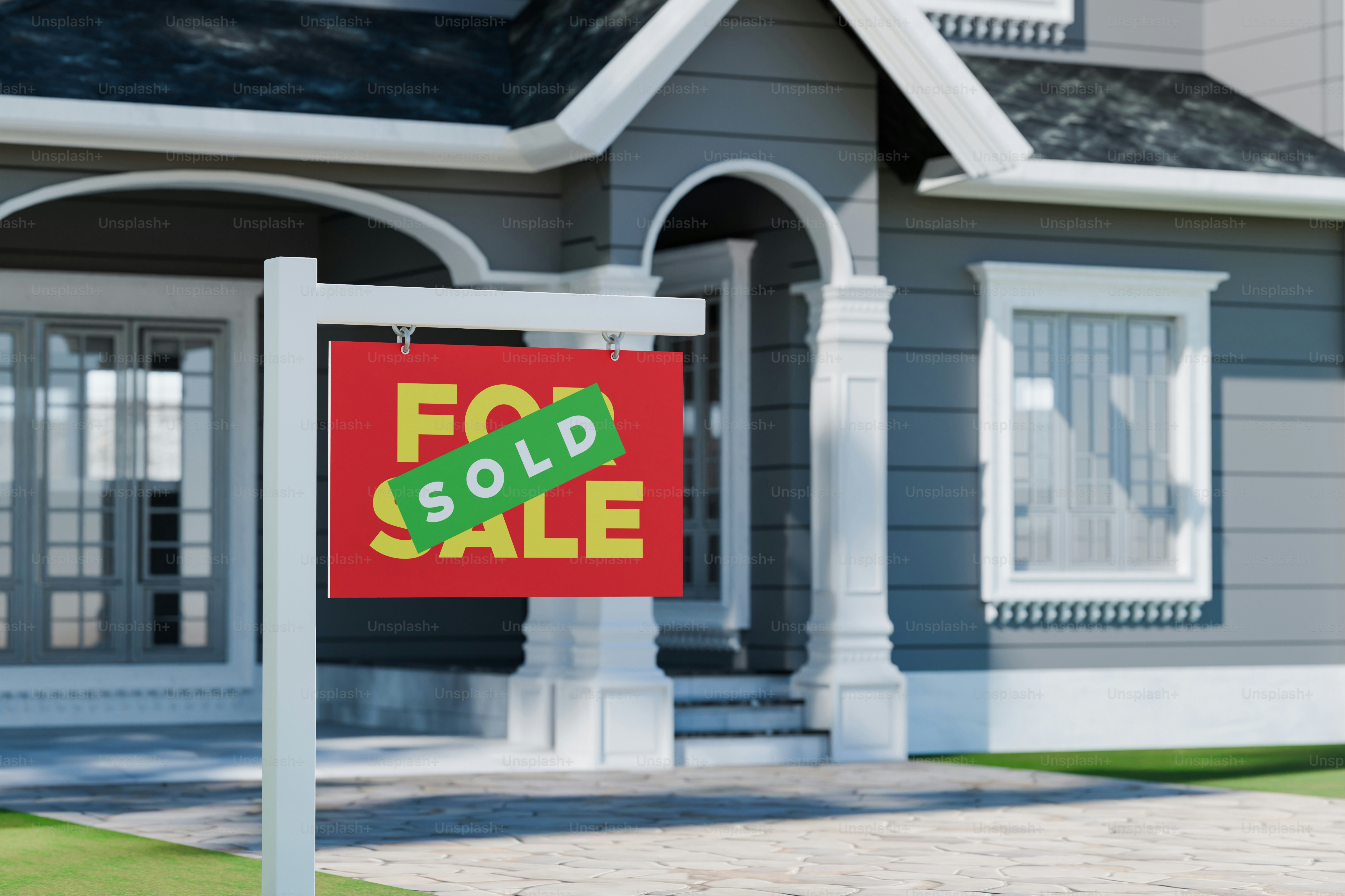 Un cartel rojo de 'se vende' con una pegatina verde vendida.