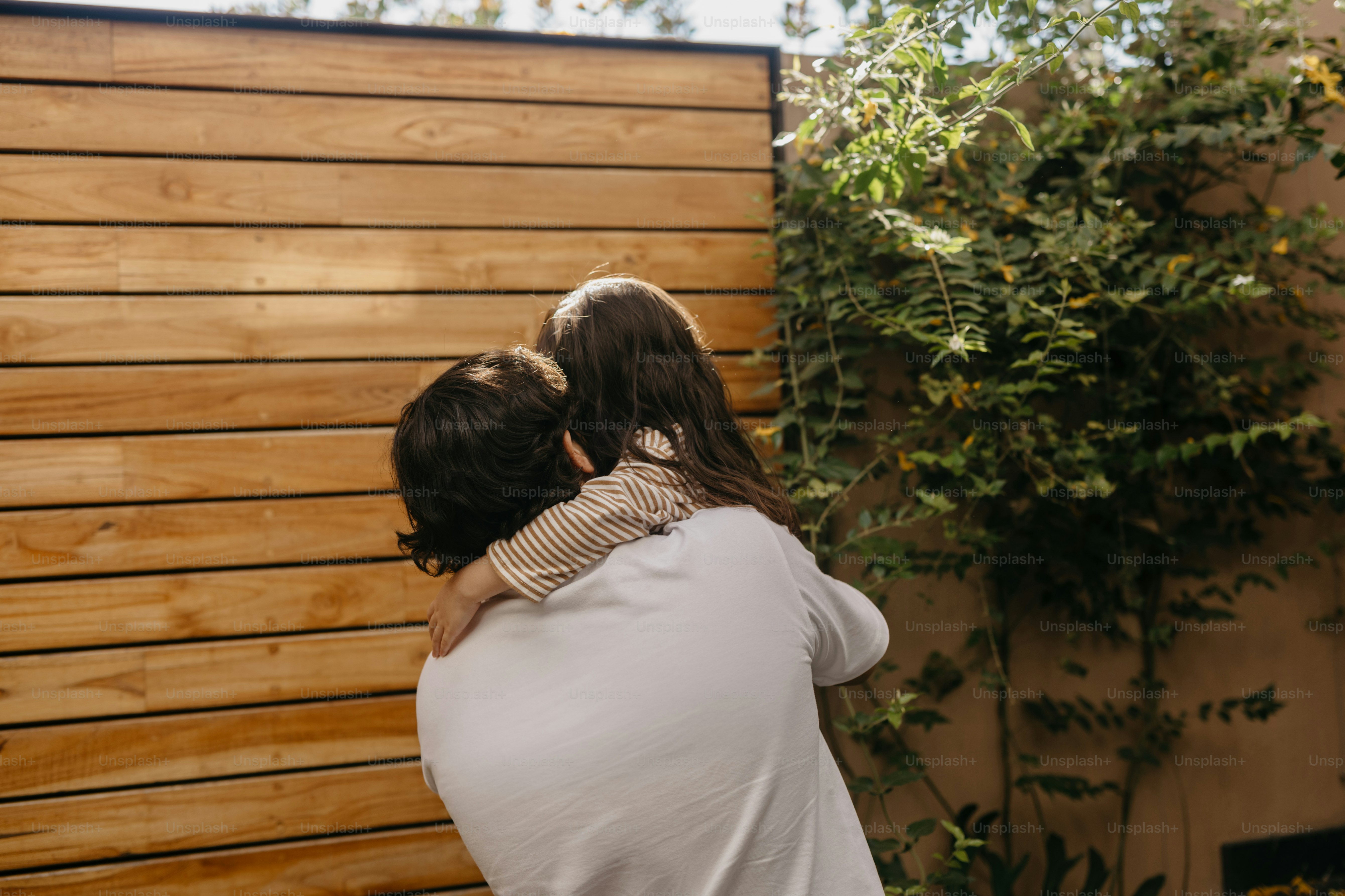 Padre che abbraccia affettuosamente sua figlia all'aperto.