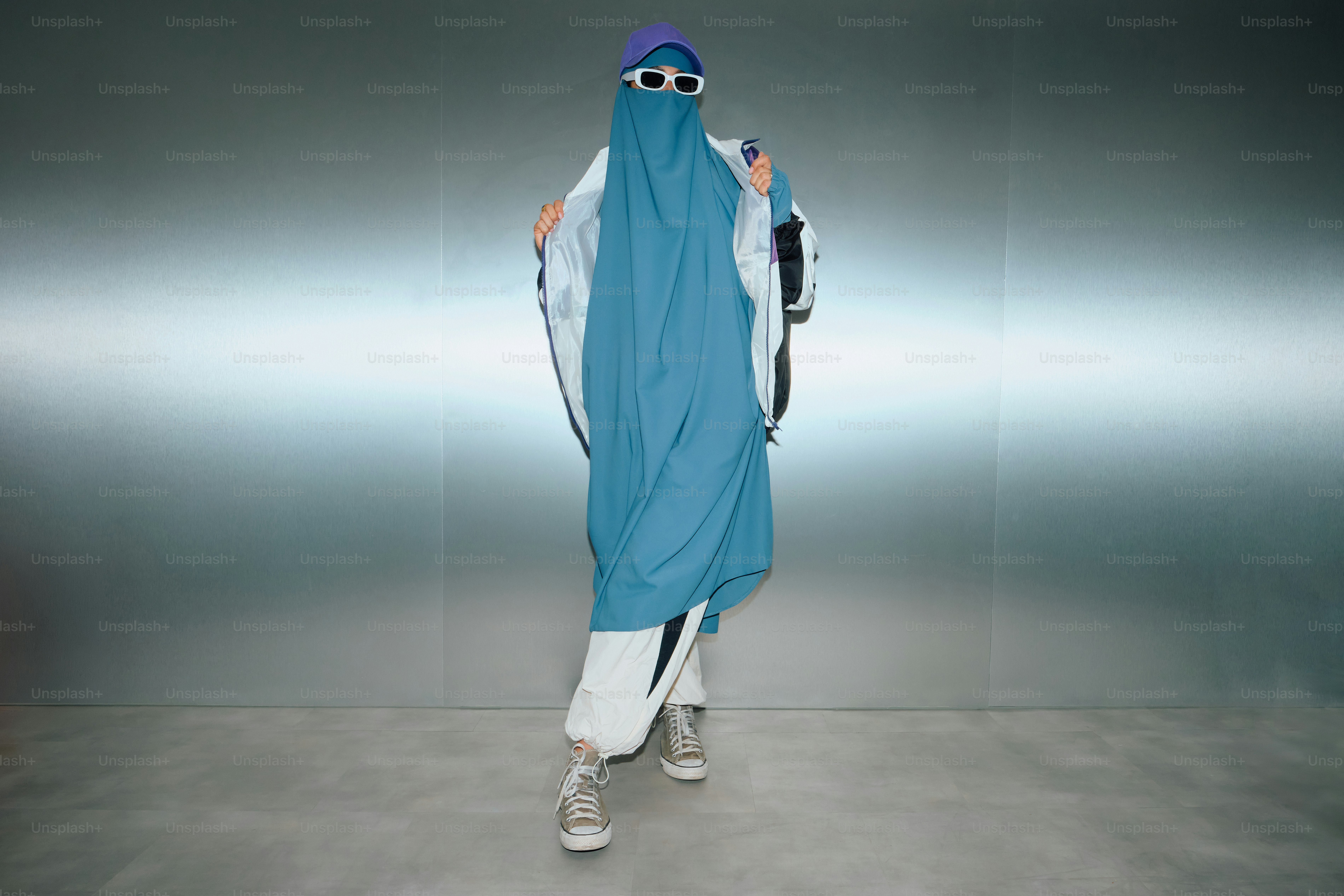 Seseorang dengan kerudung biru dan celana putih