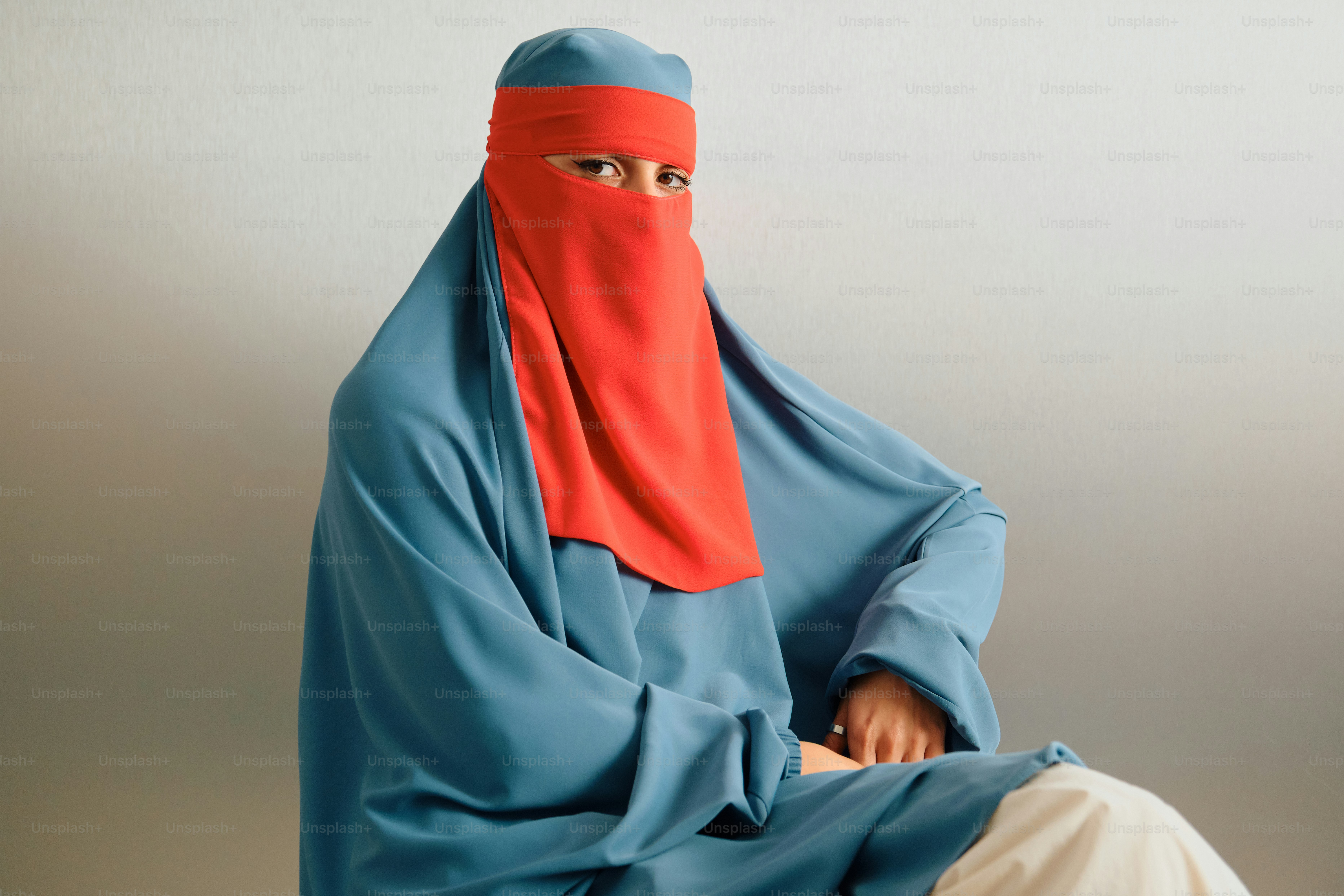 Wanita mengenakan abaya biru dan jilbab merah