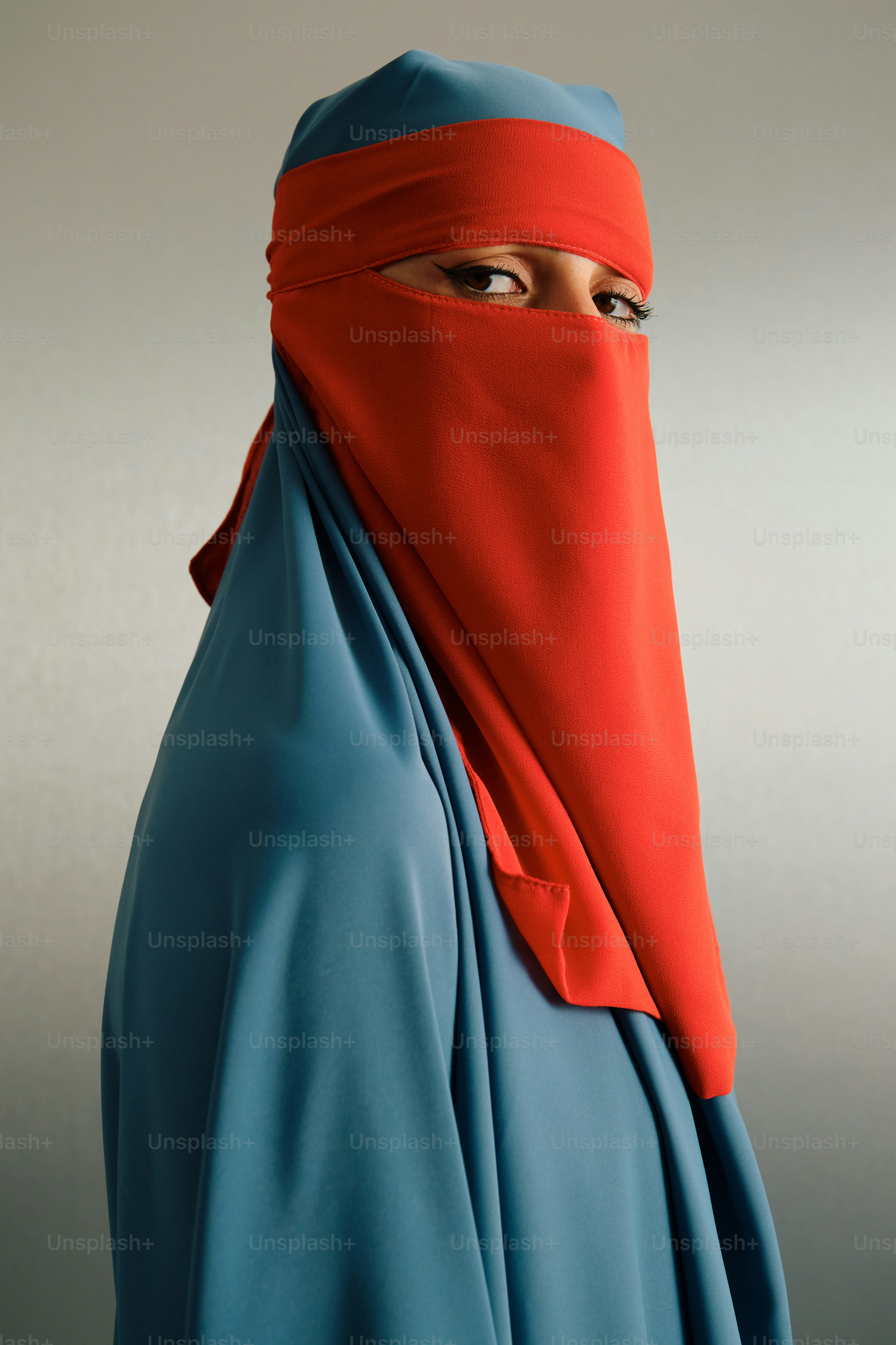 Wanita mengenakan jilbab biru dan niqab merah