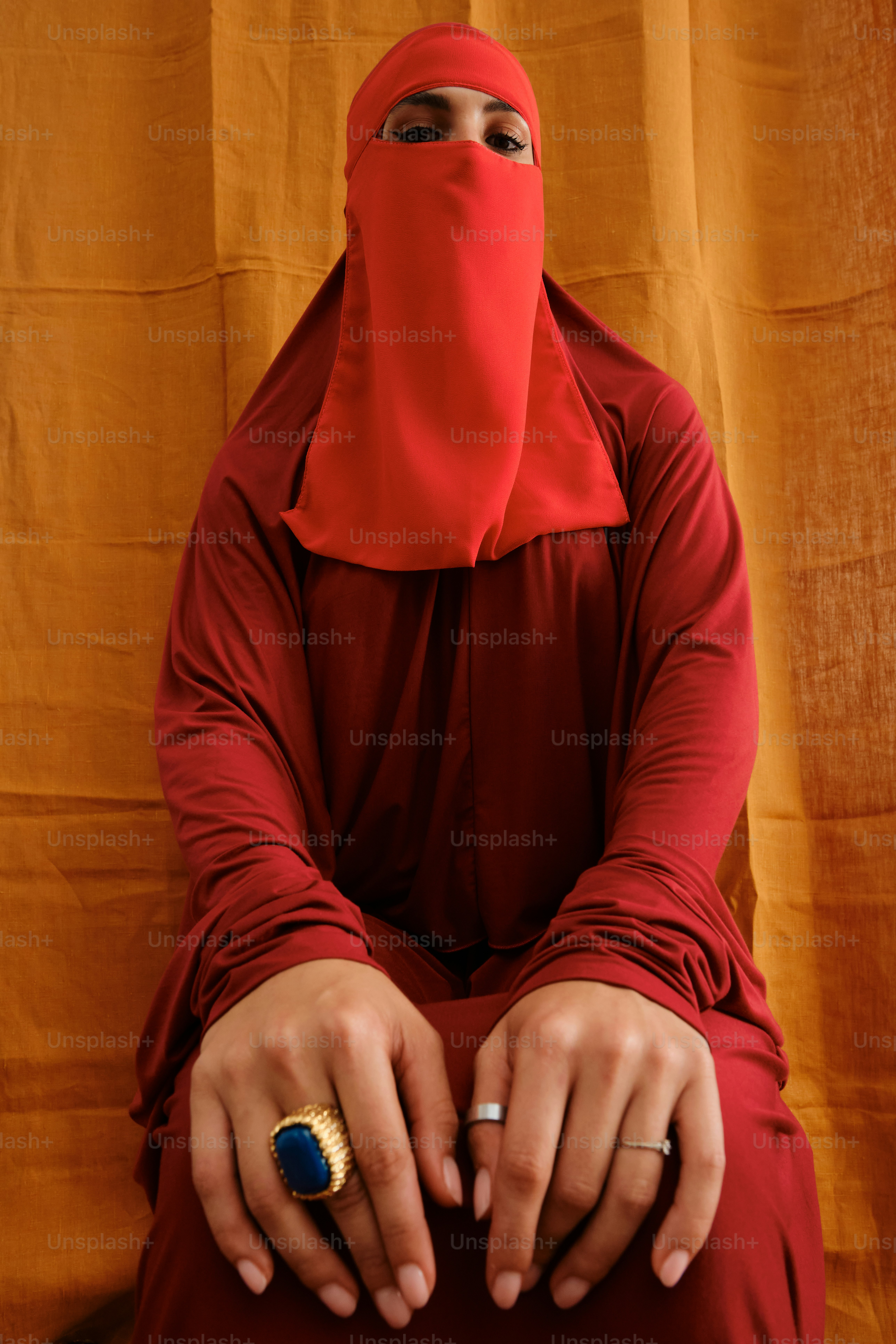 Wanita berjilbab merah dan berpakaian dengan cincin besar