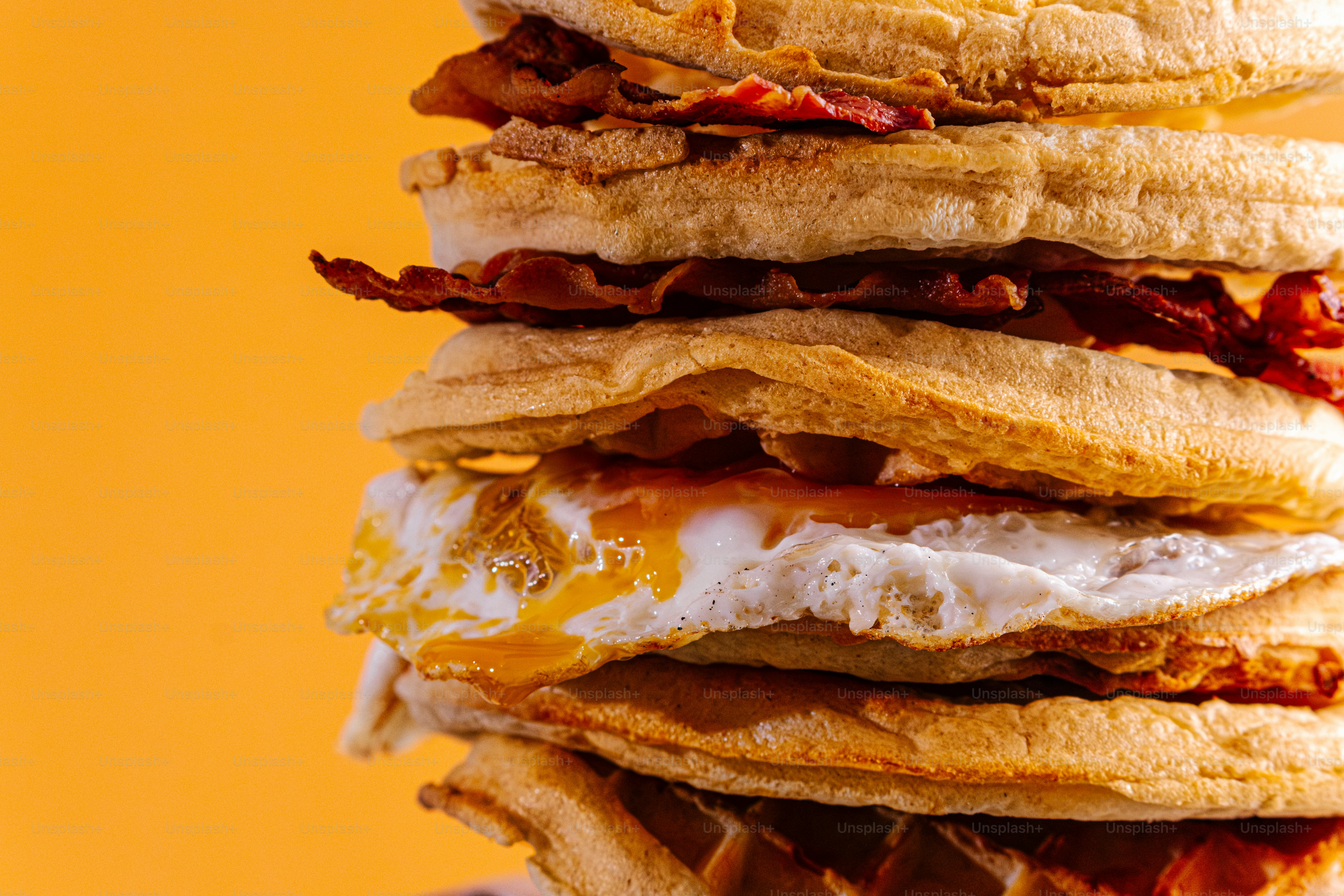 Pilha alta de waffles com bacon e ovo frito