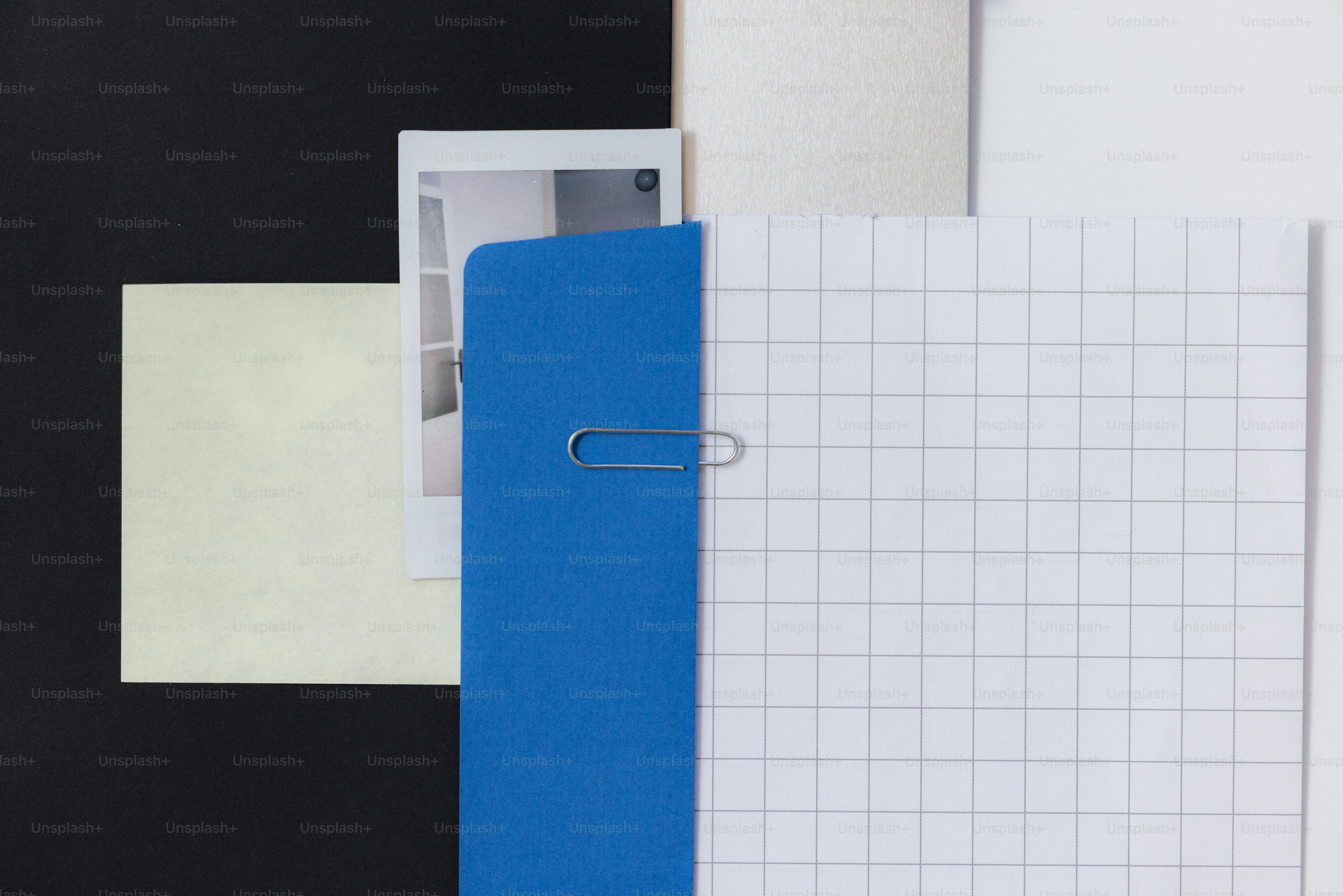 A blue folder with a paperclip and grid paper. photo – Business Image ...