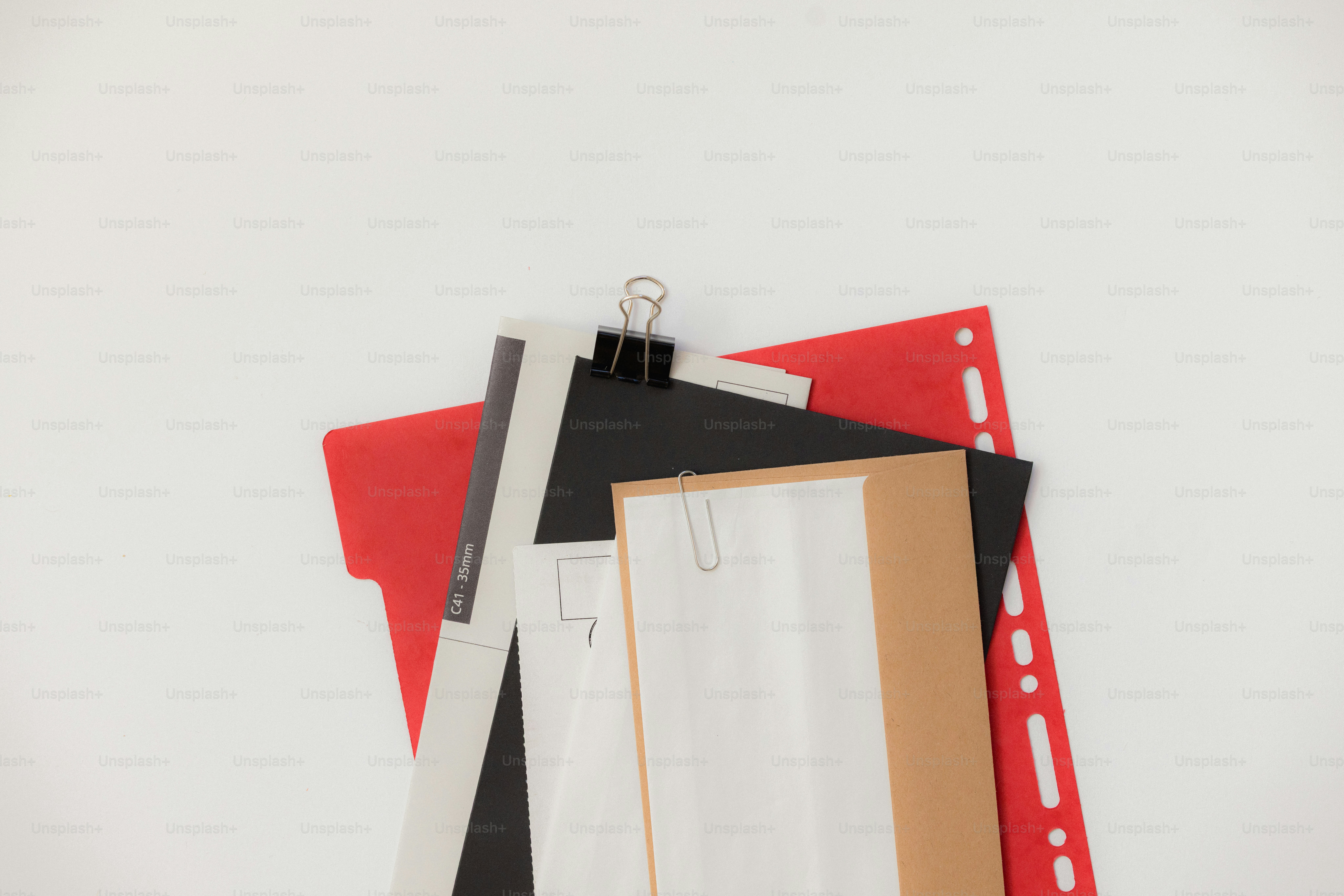 Stack of papers and red folder with binder clip photo – Paper Image on ...