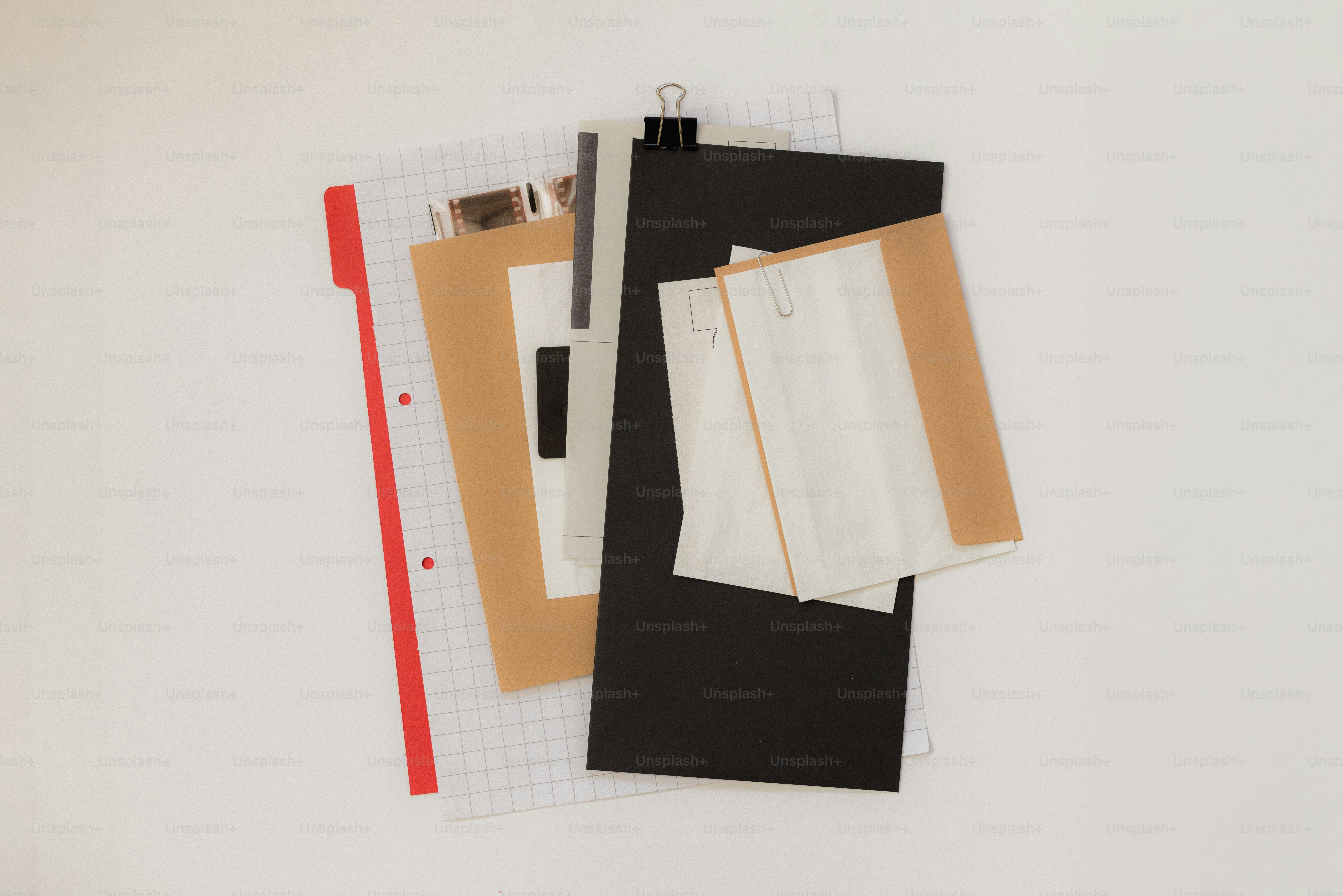 Various papers and clips on a grid notebook. photo – Study Image on ...