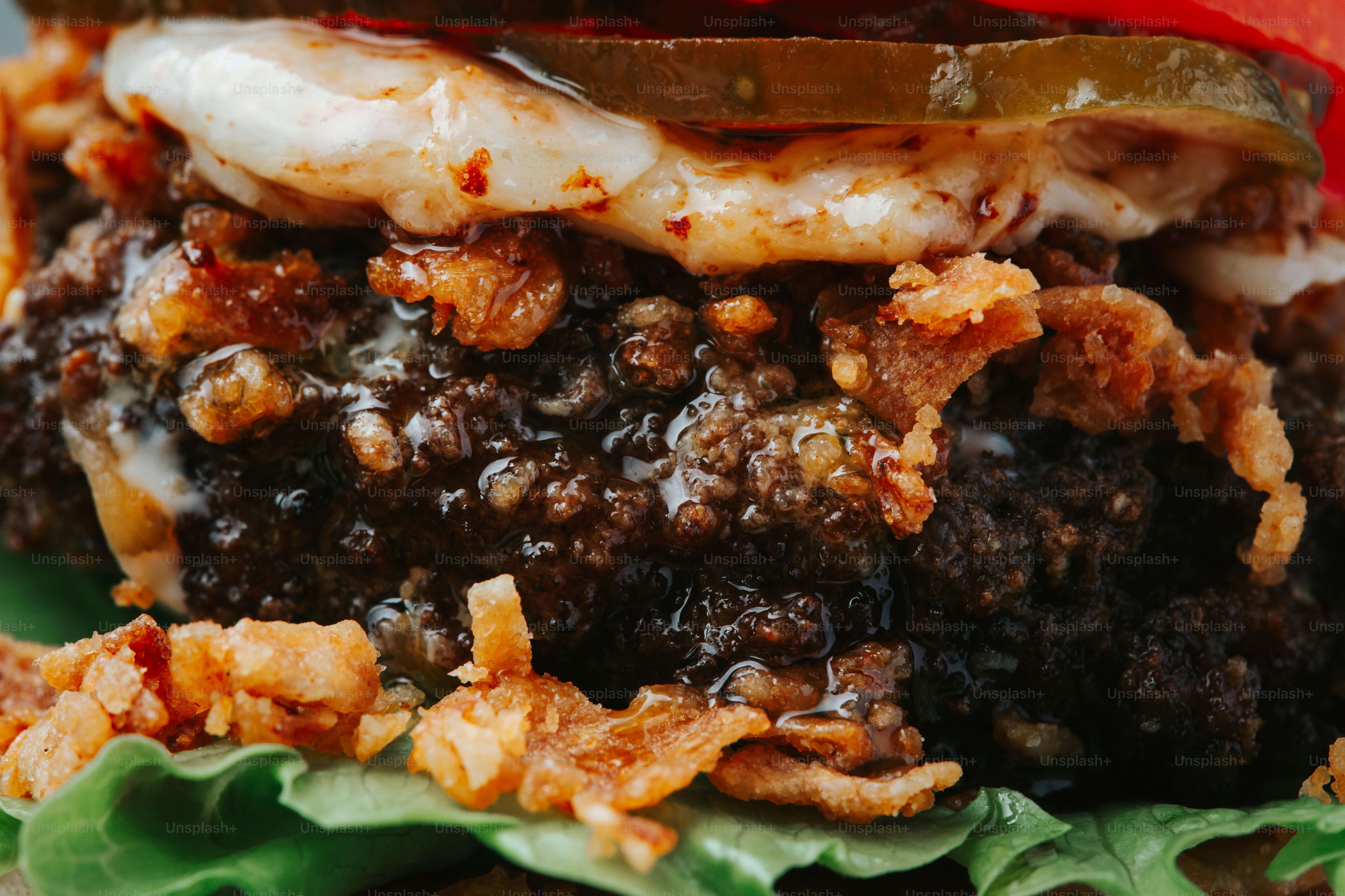 A close-up of a juicy burger with pickles and lettuce