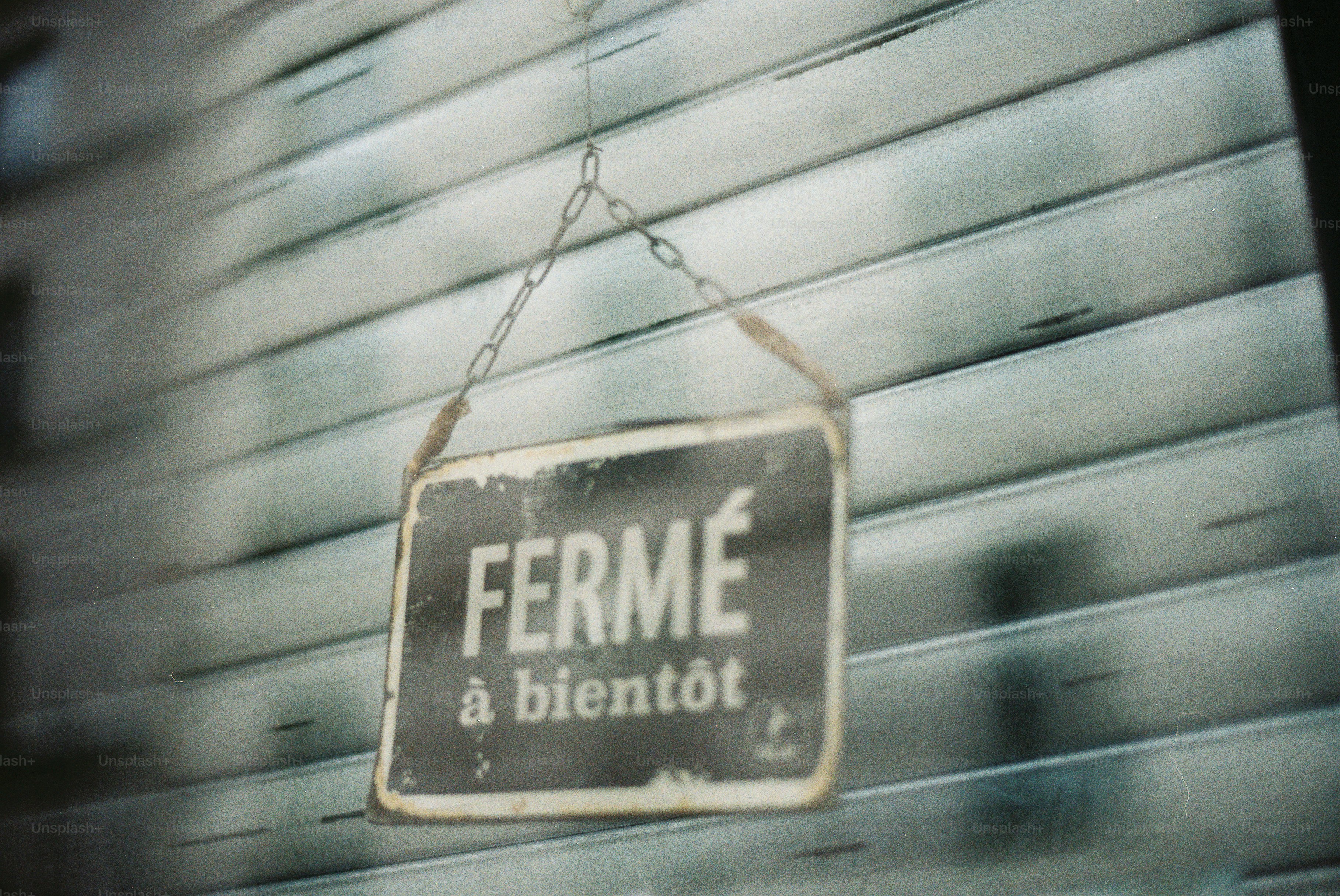 A sign reads "fermé à bientôt" hangs on a shutter